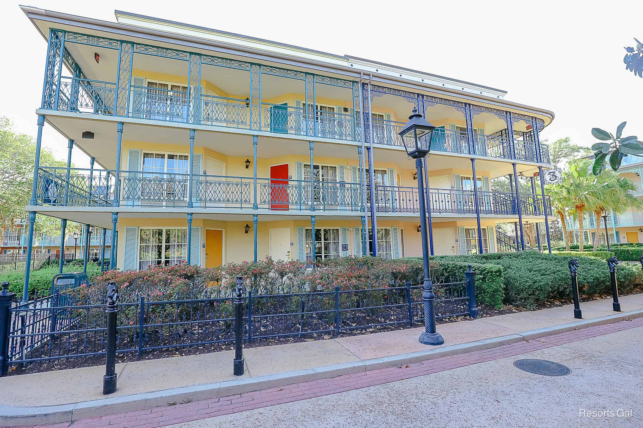 a French Quarter Resort building with cream paint and mustard yellow, red, and white doors 