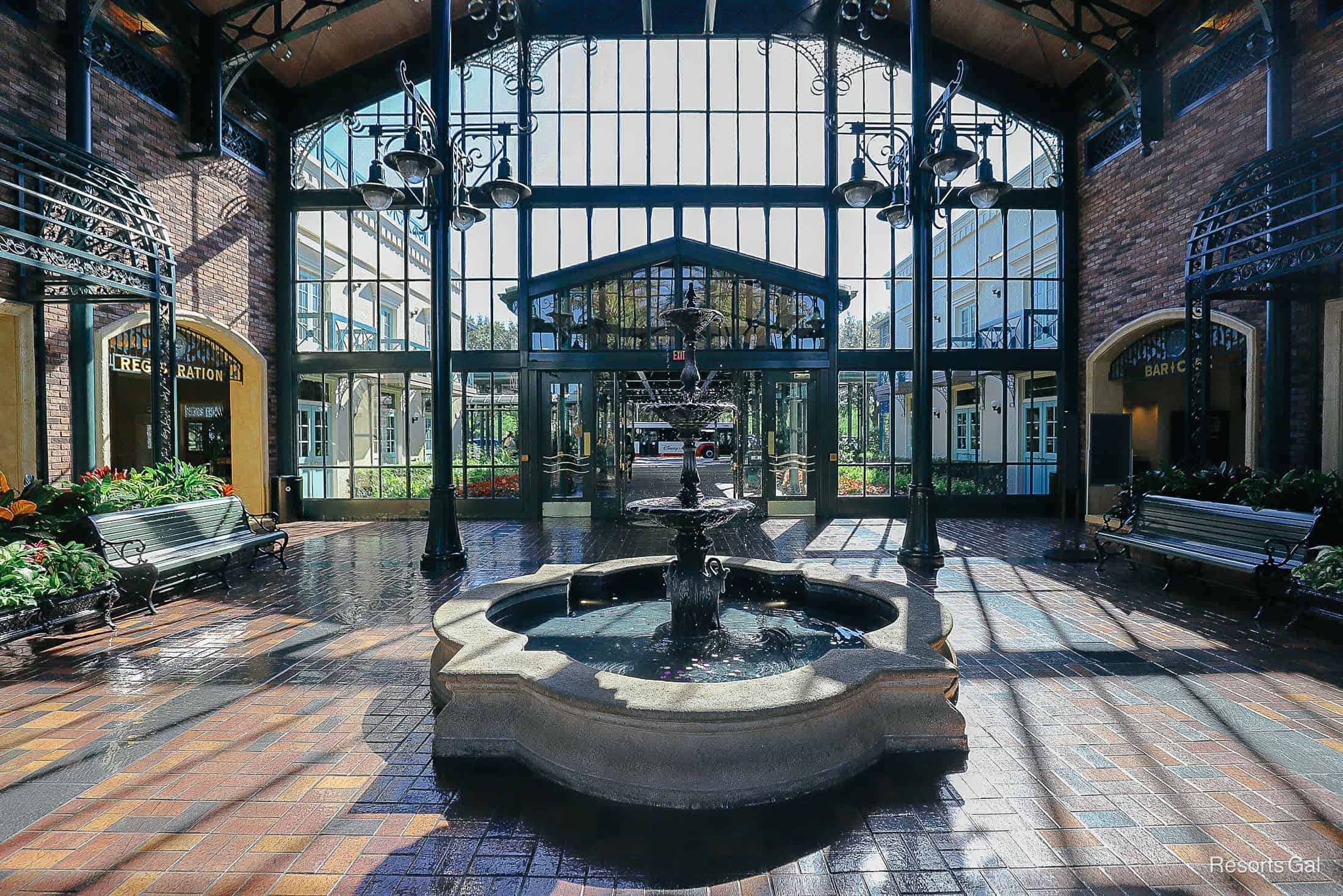a stunning view of the brick paver lobby with glass walls and sunlight 