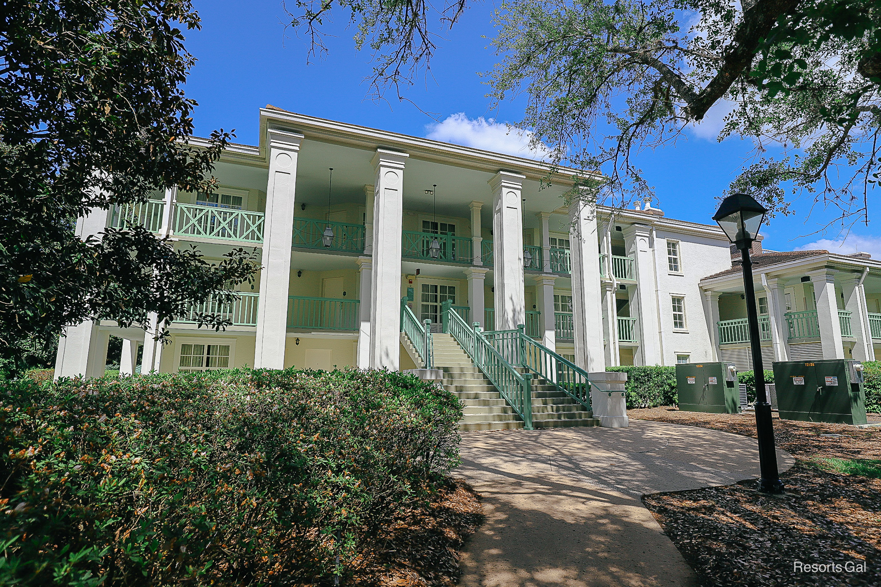Acadian House buildings have mint green railings and are three-stories with elevators 