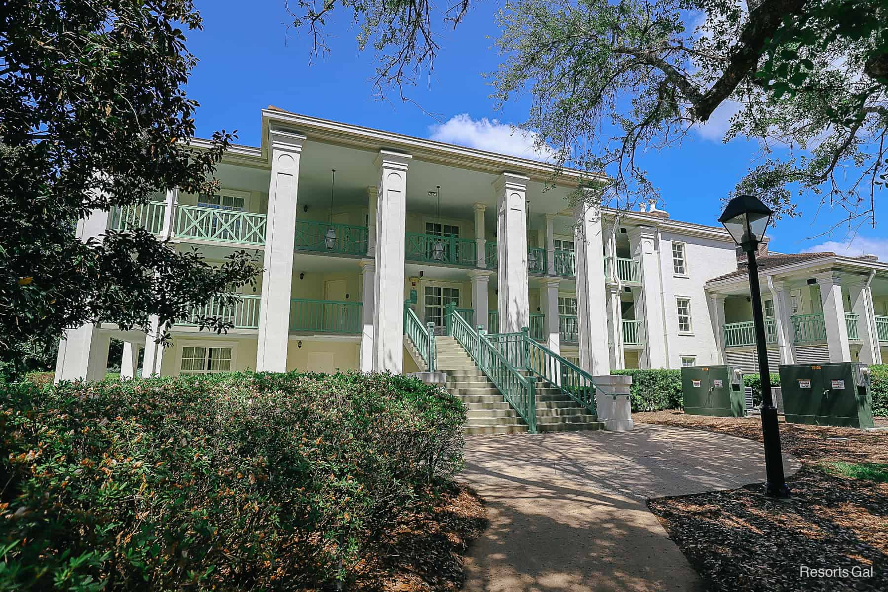 Acadian House buildings have mint green railings and are three-stories with elevators 