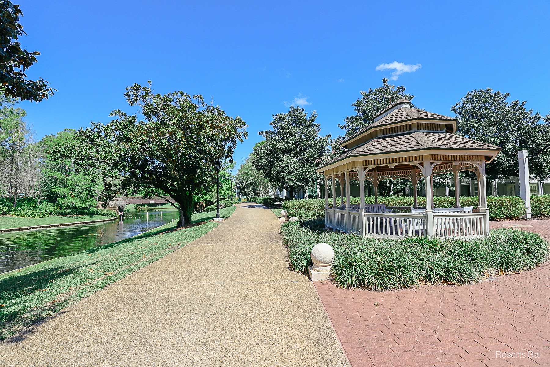 a sidewalk with a gazebo to the right side 