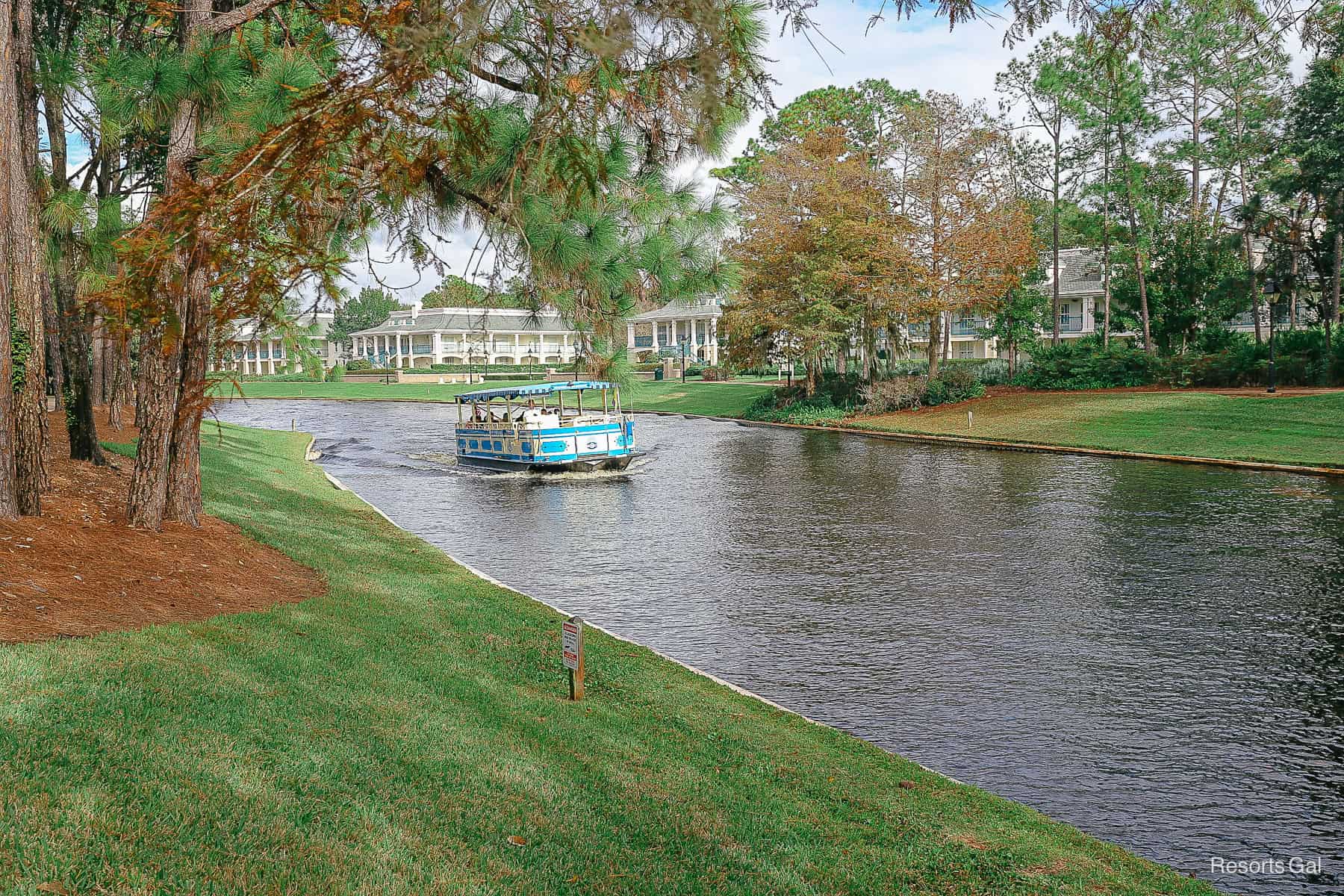 a water taxi traveling down the river in front of the mansions 