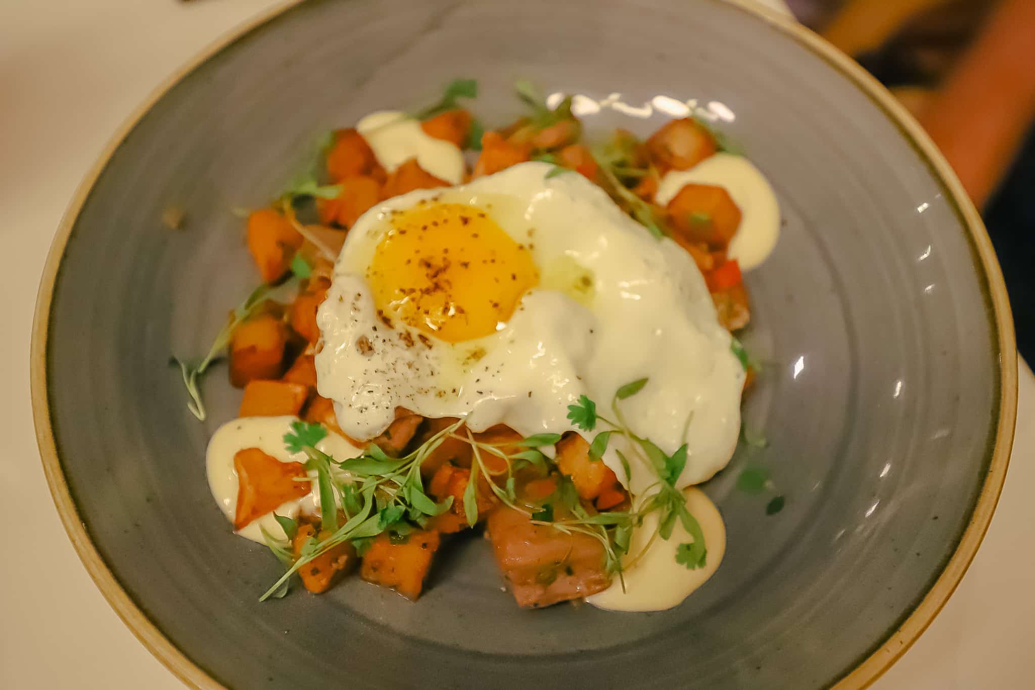 a breakfast hash with potatoes and a runny egg on top