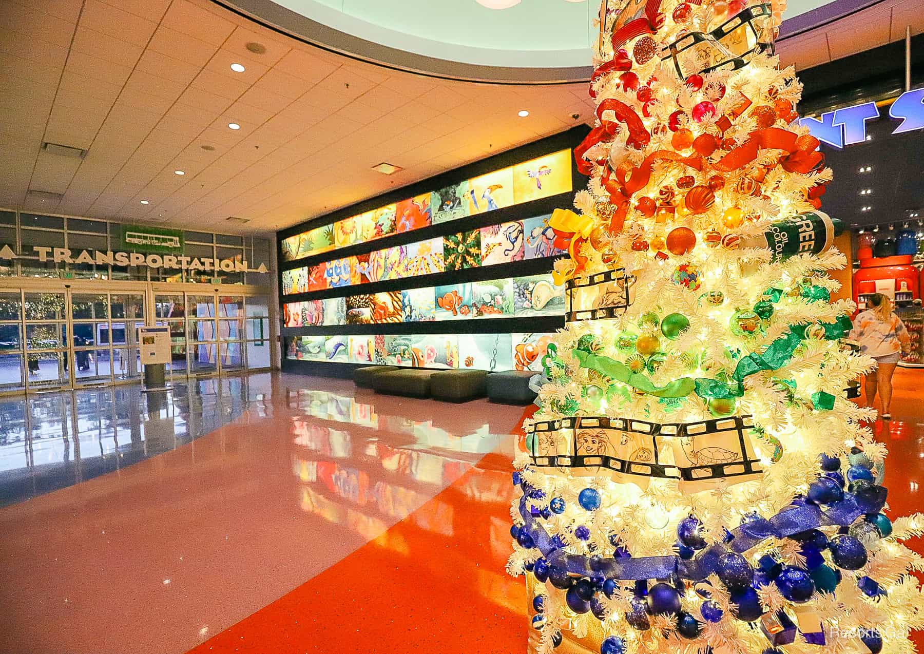 a white tree with blue, green, orange, an red decorations wrapped around it 