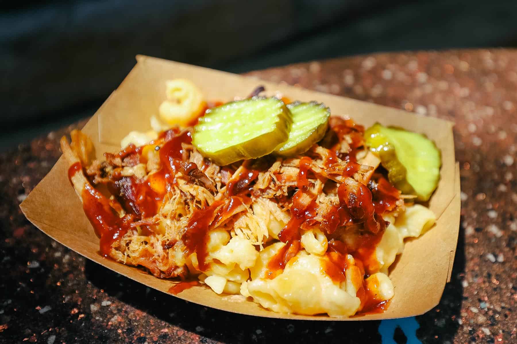 a snack with macaroni and cheese topped with barbecue and pickles from Disney's Animal Kingdom 