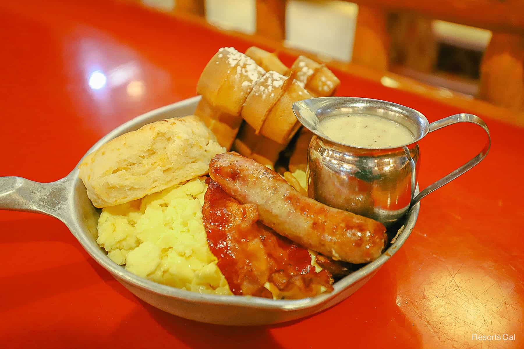 a breakfast skillet from Disney World with biscuits, eggs, bacon, sausage, gravy, and Mickey waffles. 