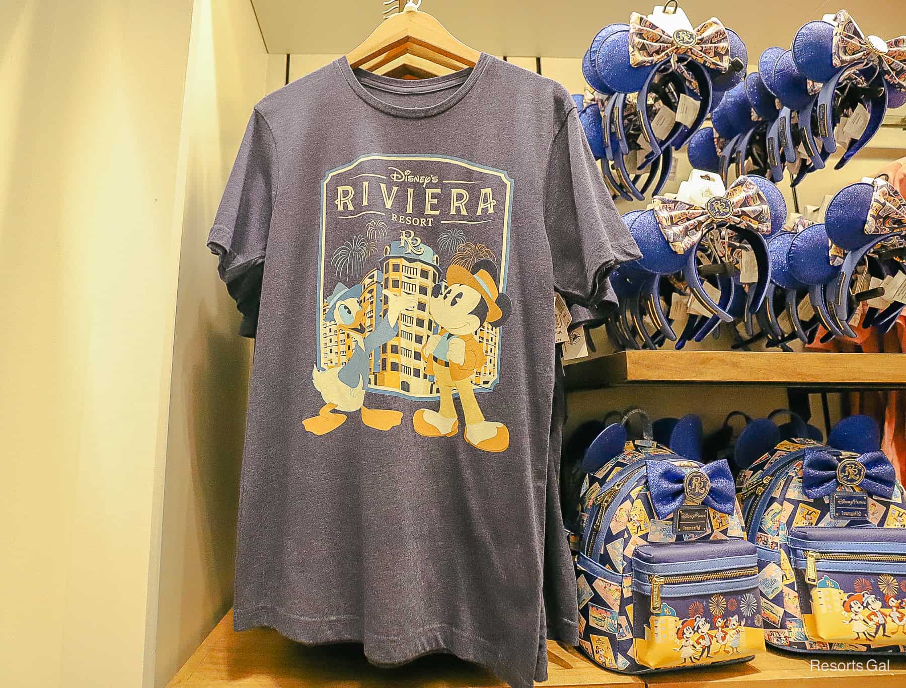a resort logo shirt with Mickey and Donald standing in front of the Riviera Resort 