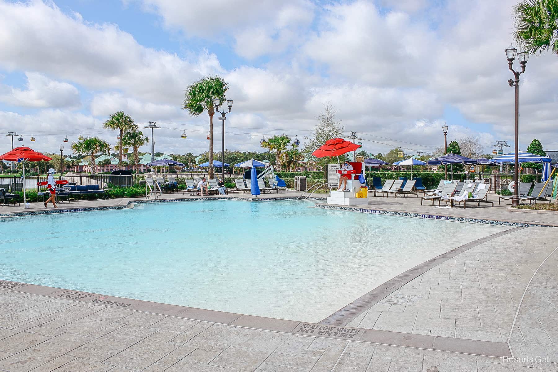 the zero-depth entry side of the Riviera Pool with red umbrellas over the life guard chair 