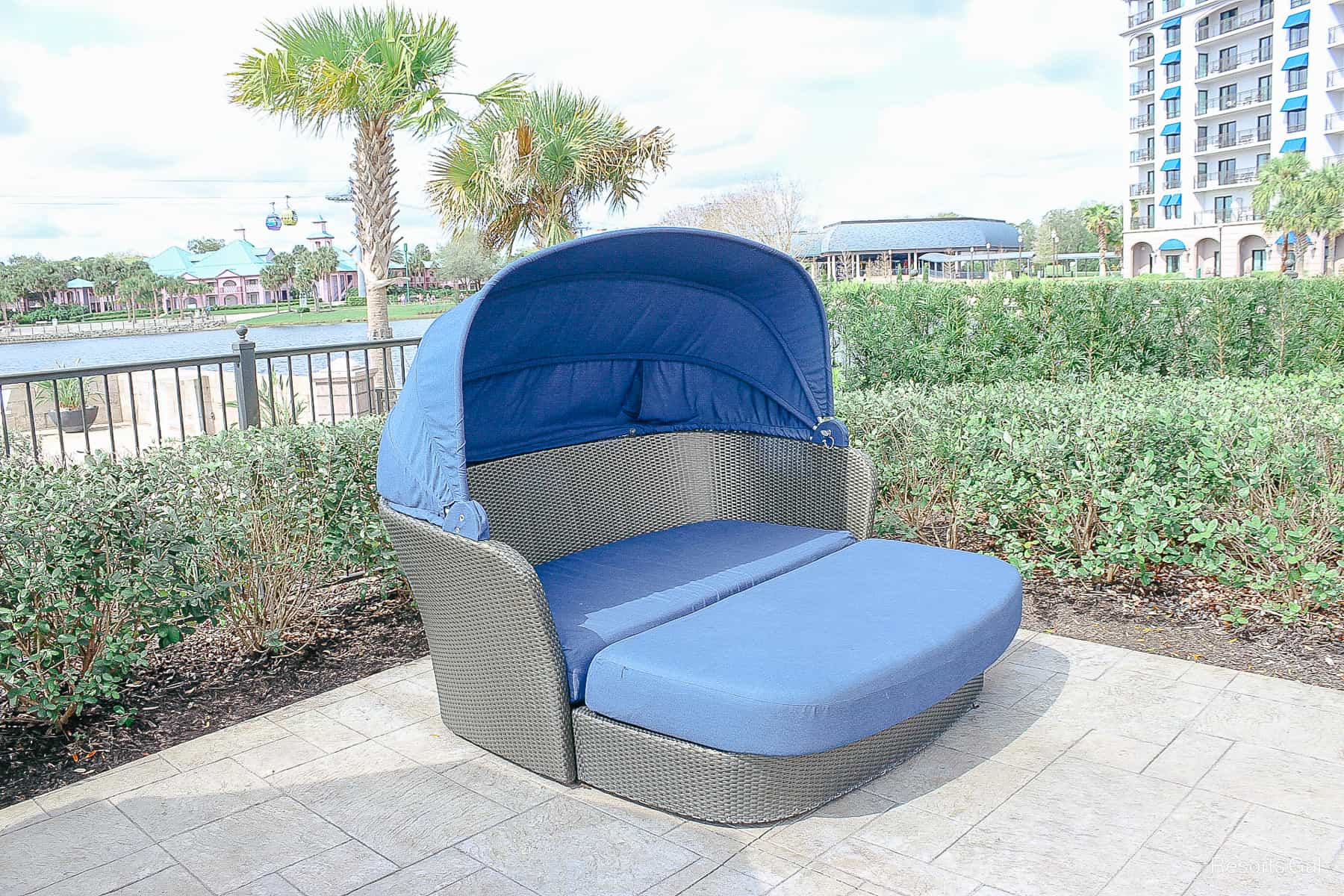 a blue lounger with a shade cover and an ottoman