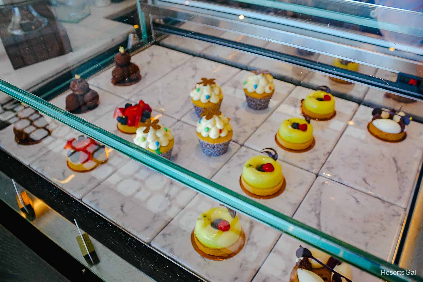 a case with pastries, cupcakes, and desserts 