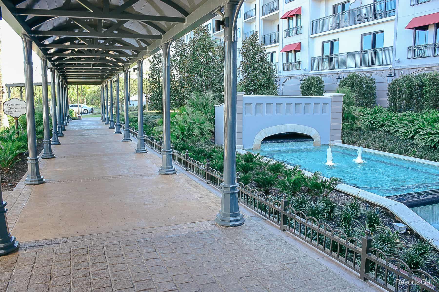 the walkway that leads to the entrance with a water fountain to the right side 
