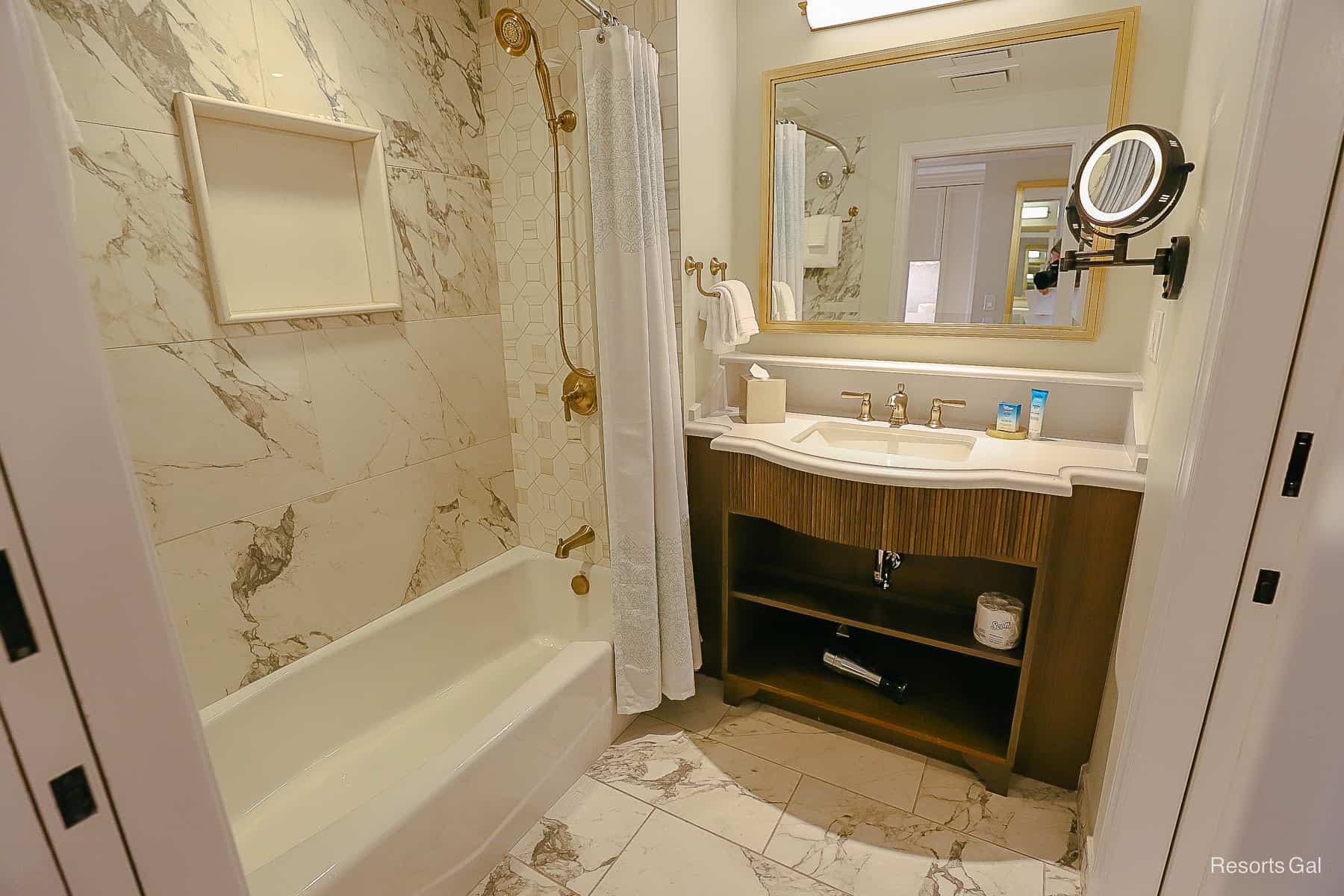 the split bathroom has one side with a tub and shower combination and a full vanity 