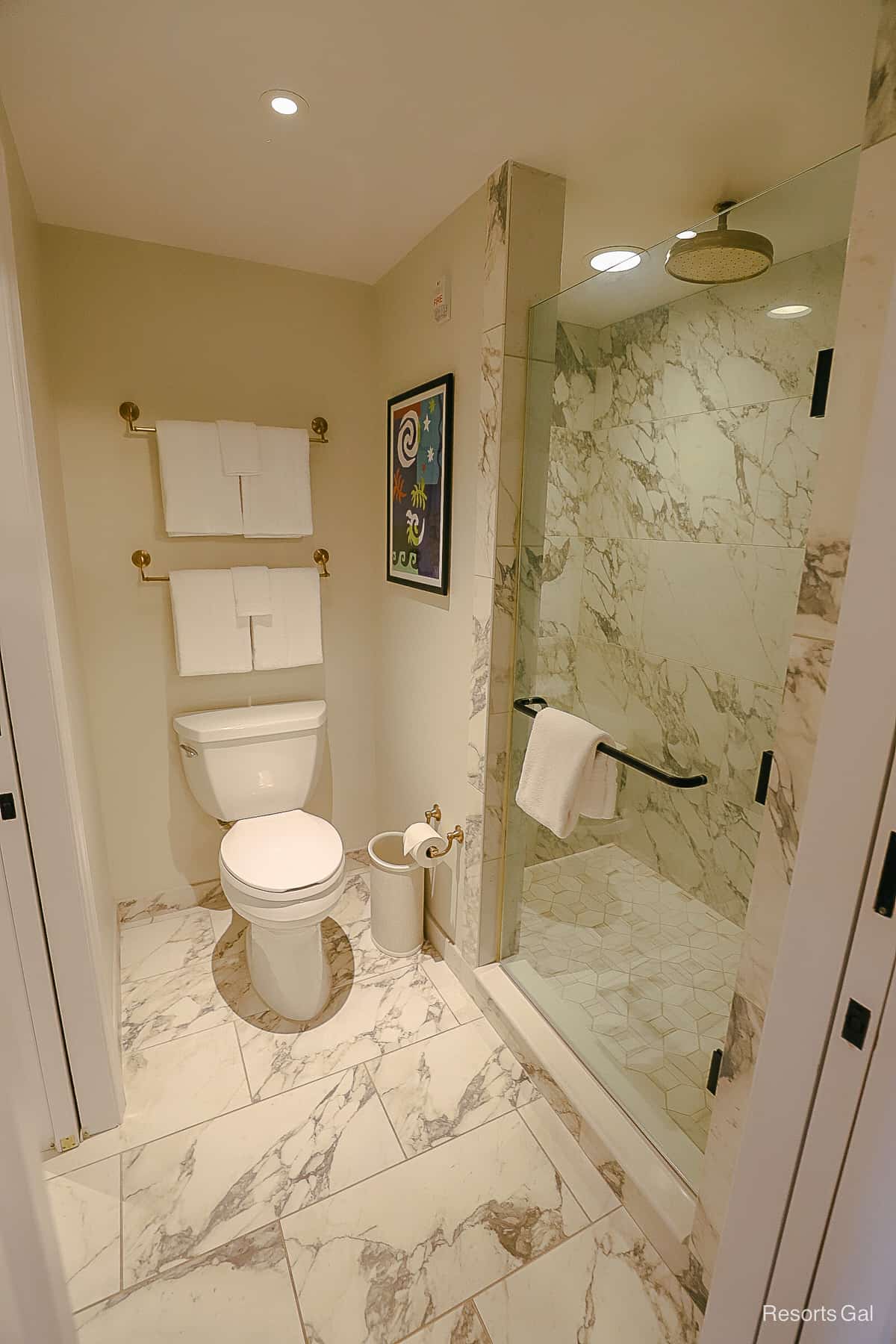 marble floors and a glass door to the shower 