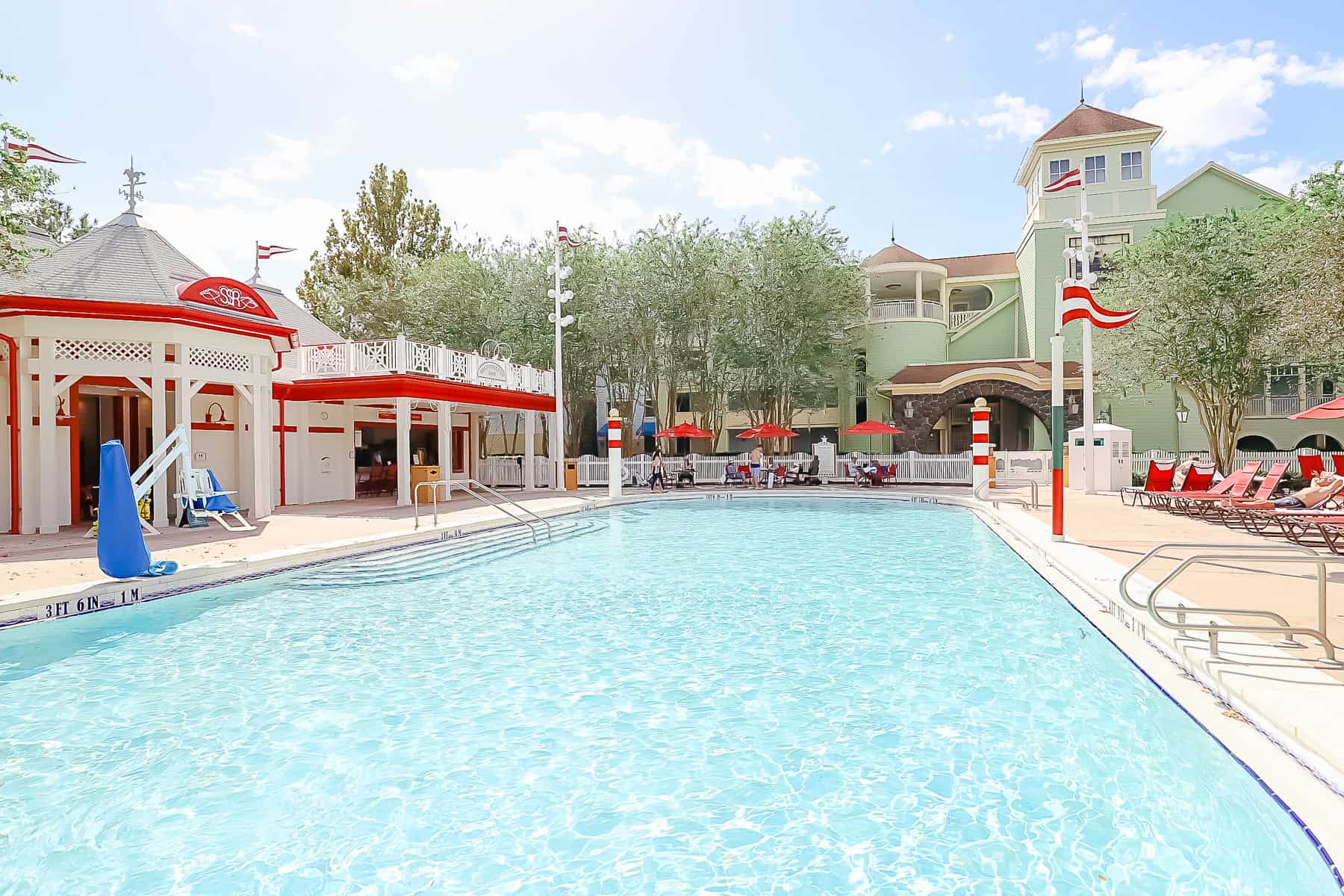 the blue waters of the pool with the red and white backdrop of The Grandstand at Saratoga Springs 