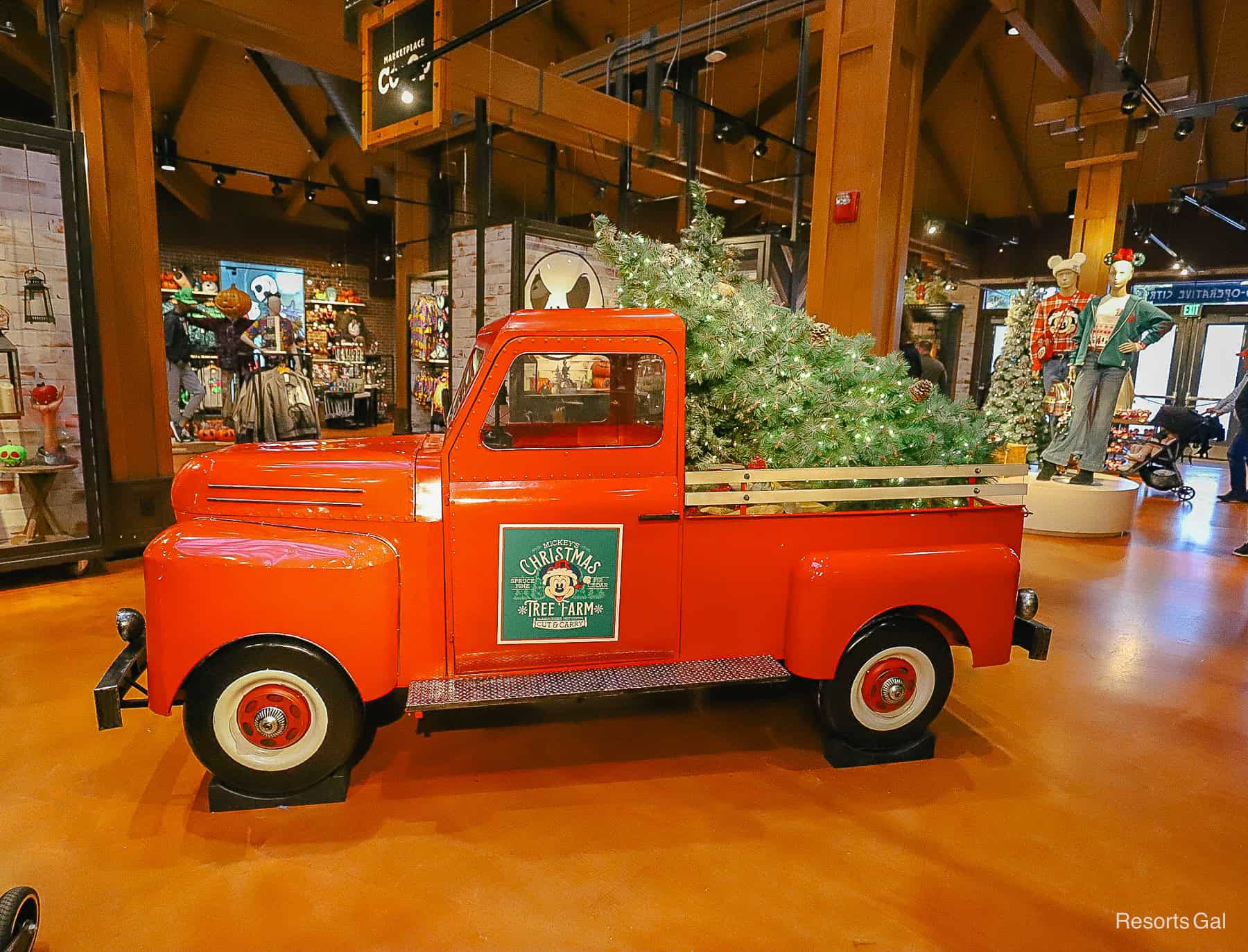 a red truck that says Mickey's Christmas Tree Farm in the middle of Tren-D at Disney Springs 