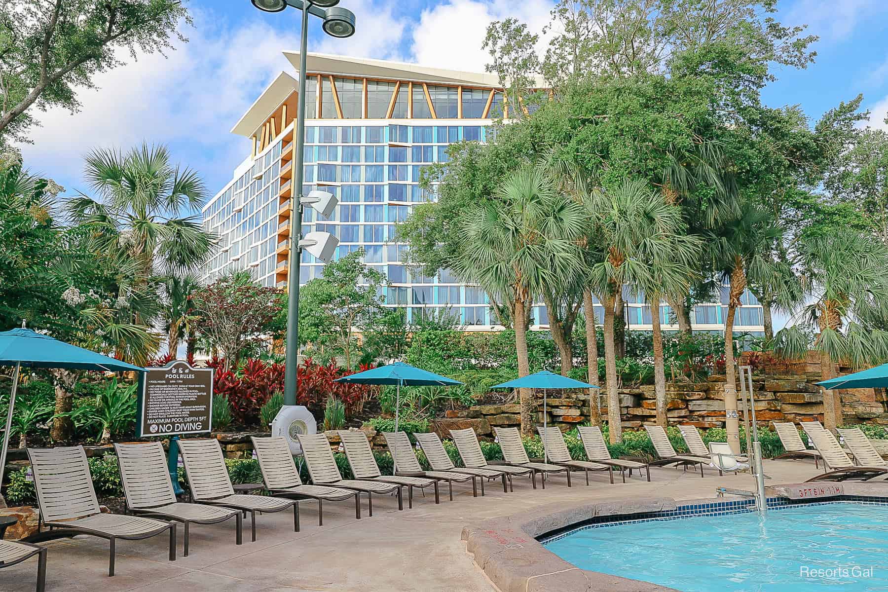 a row of lounge chairs sitting around the Grotto Pool with the Swan Reserve in the background 