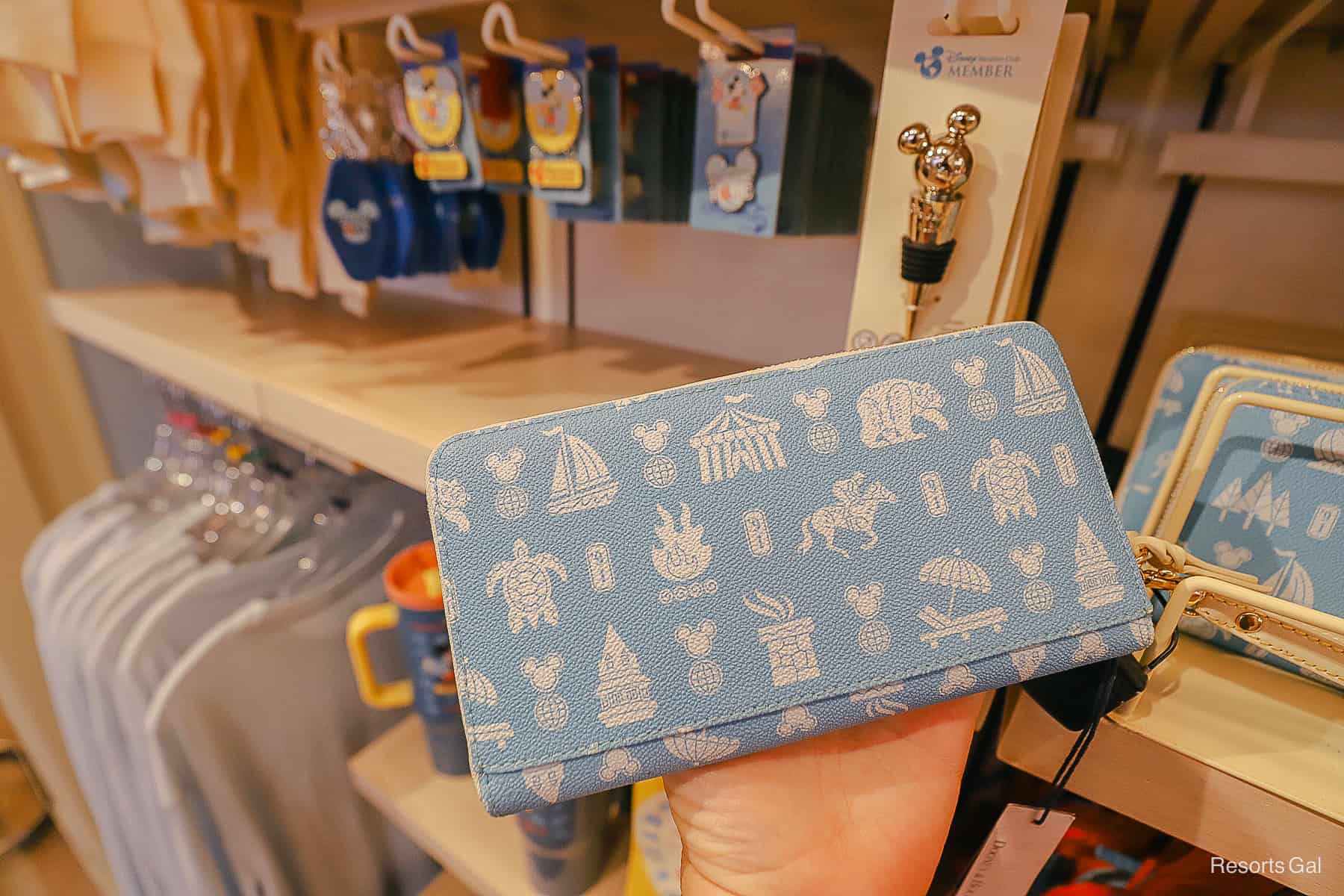 back side of the light blue Disney Vacation Club Dooney and Bourke wallet with cream icon print