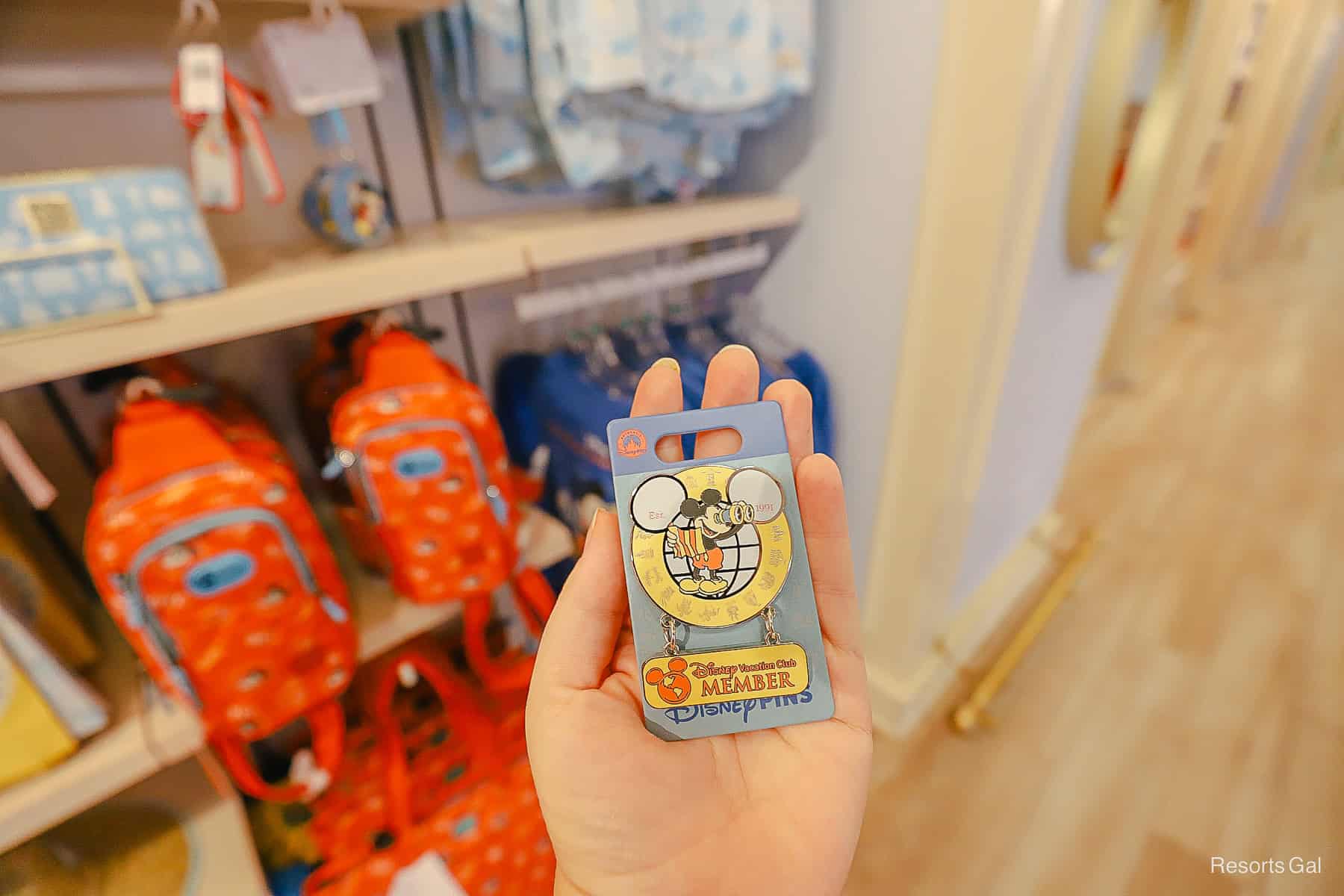 a pin with Mickey Mouse and a map with chains holding a sign that says Disney Vacation Club Member
