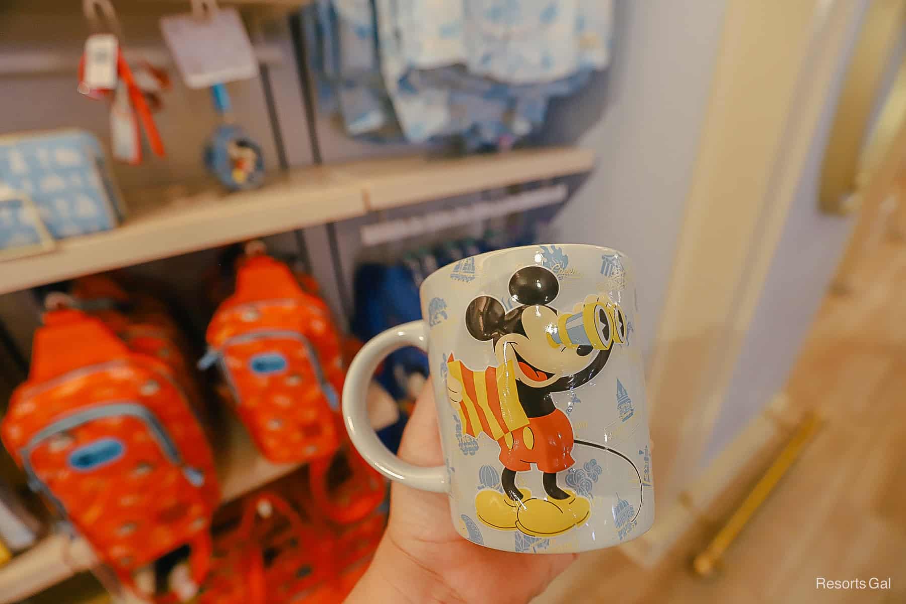 front of the new Mickey Mouse DVC mug with Mickey looking through a pair of binoculars while holding a map