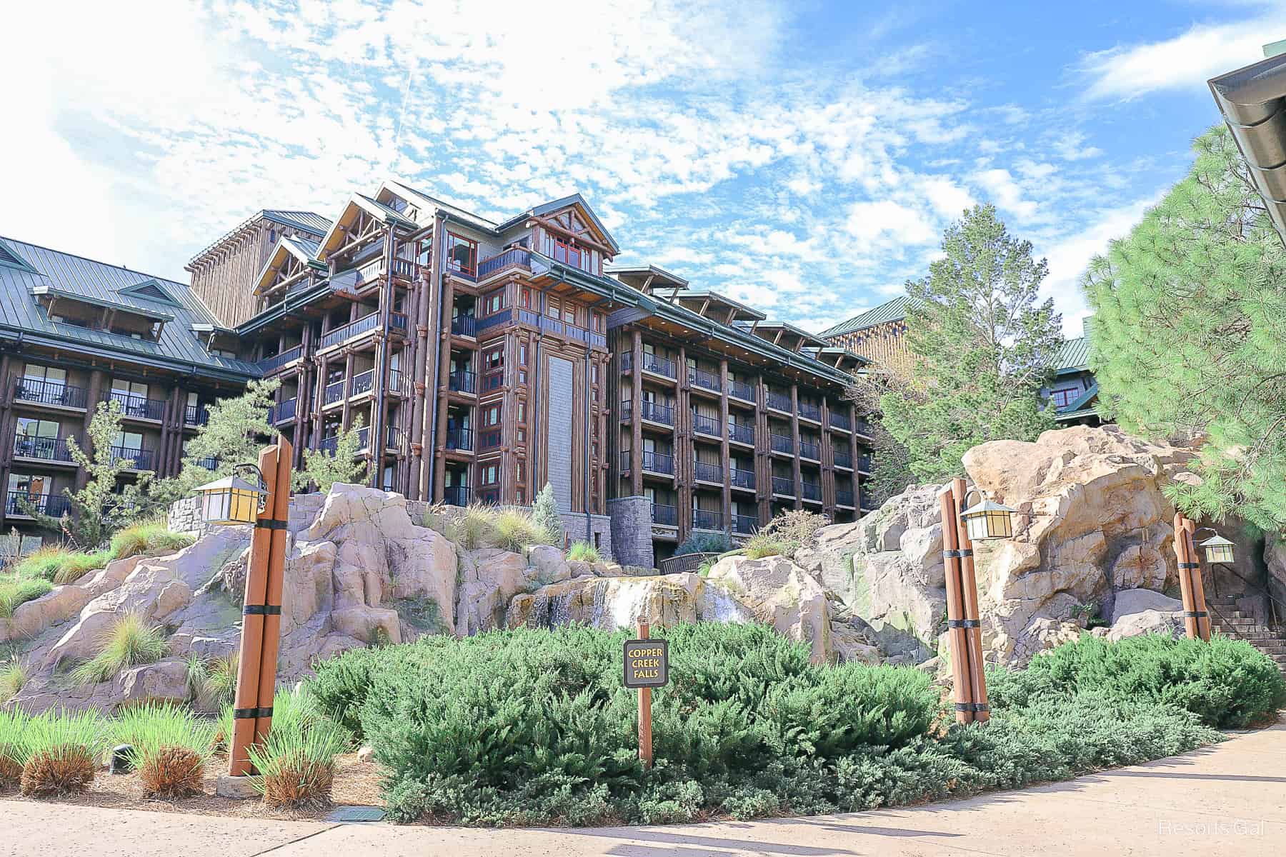 a scenic view of the resort with green trees and cloudy blue skies 