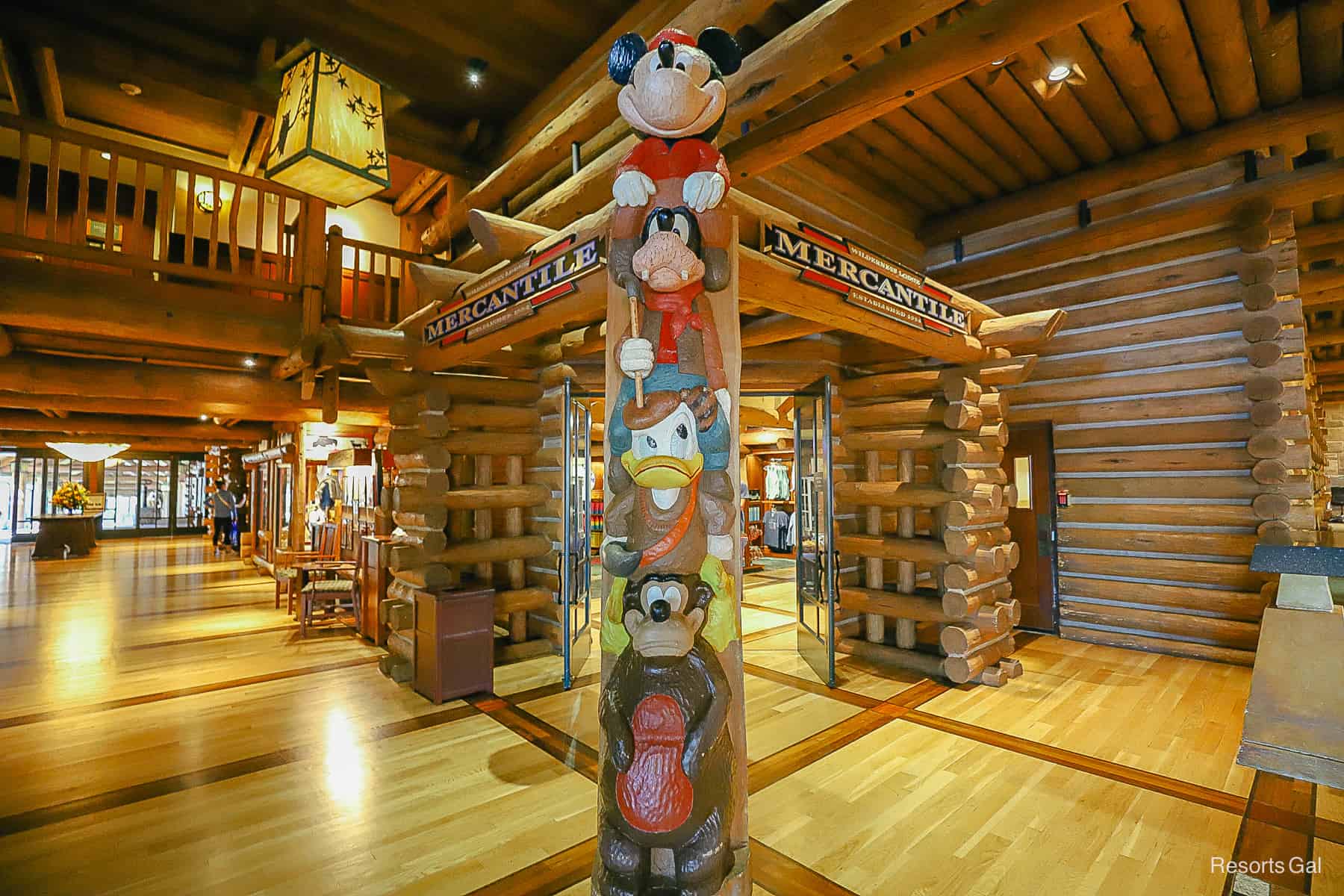 a totem pole in front of Wilderness Lodge Mercantile with Humphrey, Donald, Goofy, and Mickey 