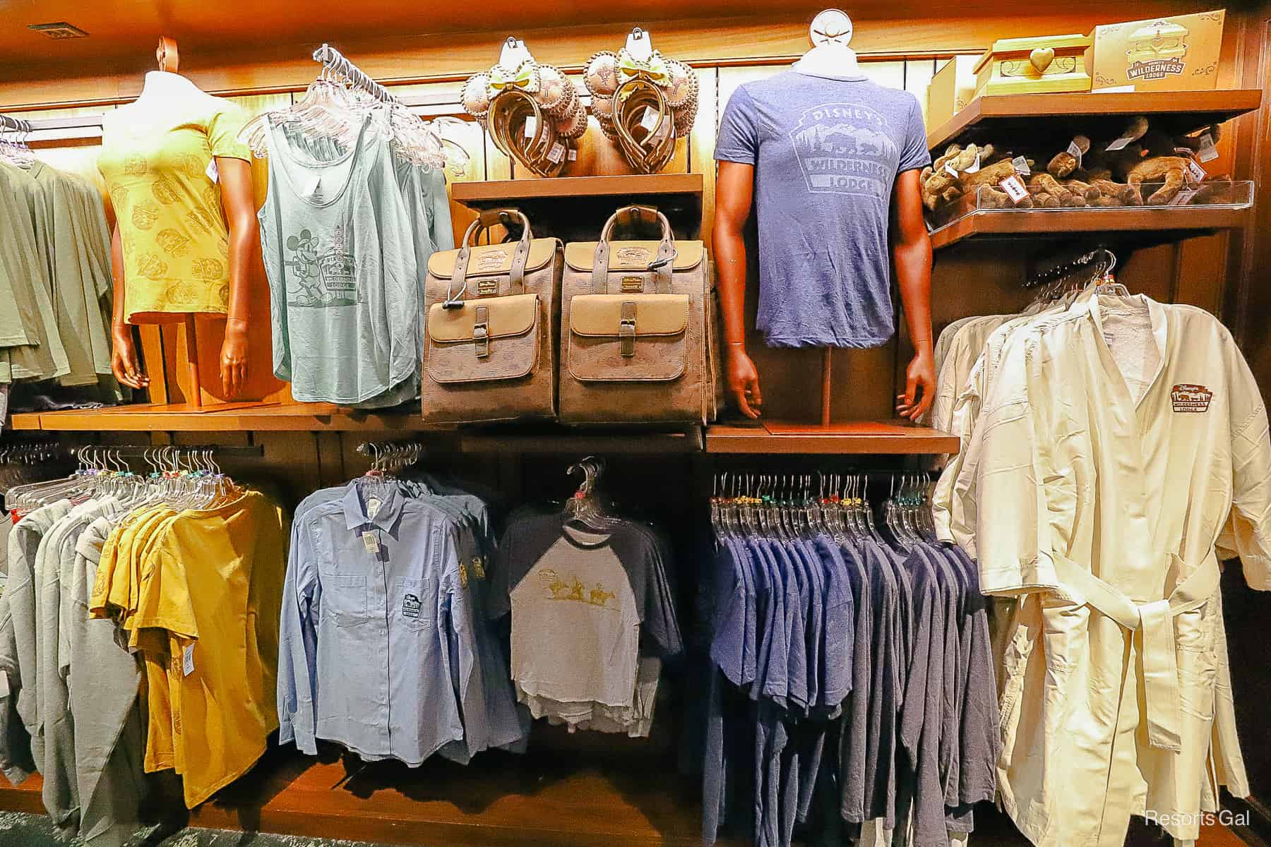 a display that features a mix of Wilderness Lodge t-shirts, backpacks, and tank tops 