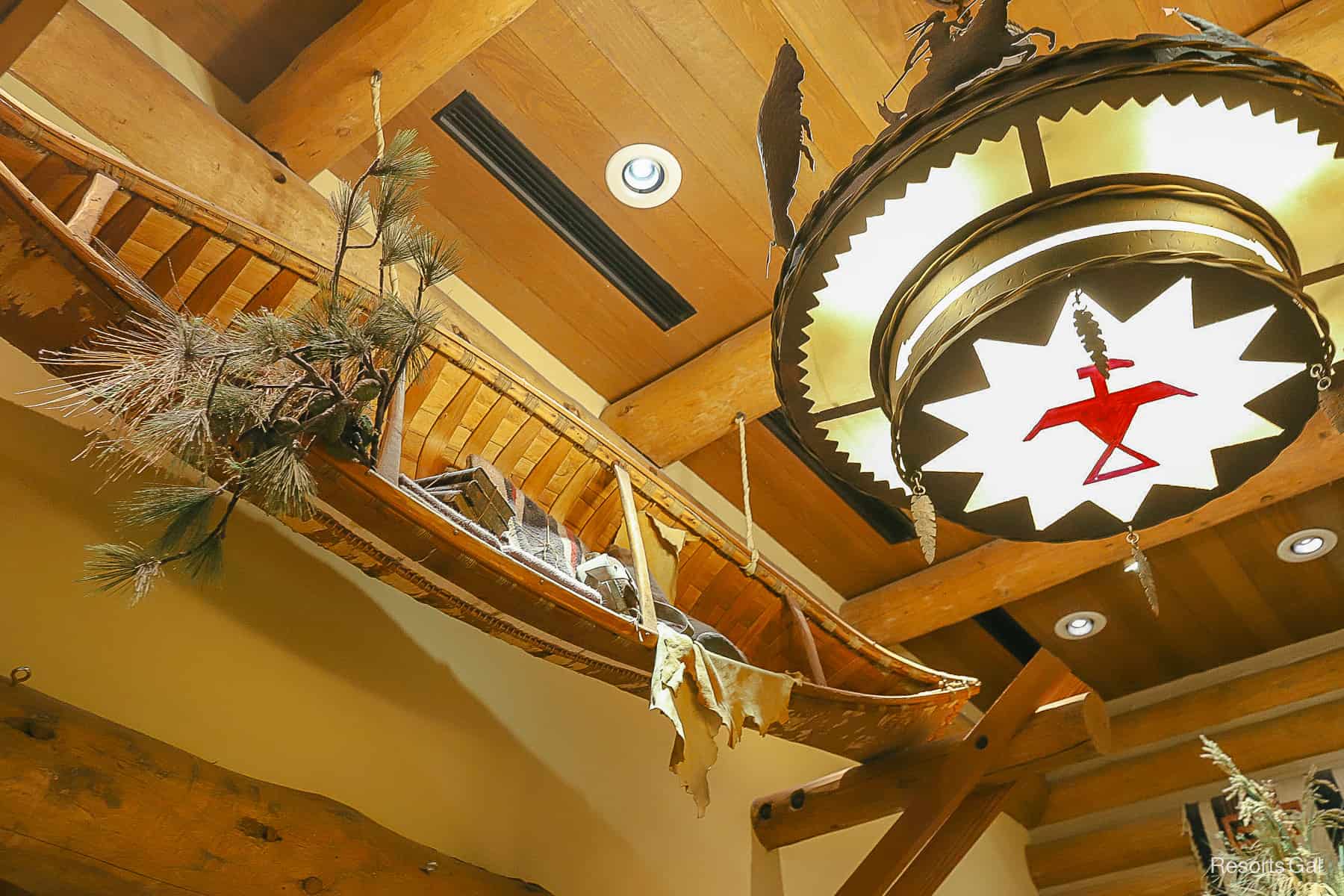 a light fixture with Native American theming and a canoe hangs from the ceiling 