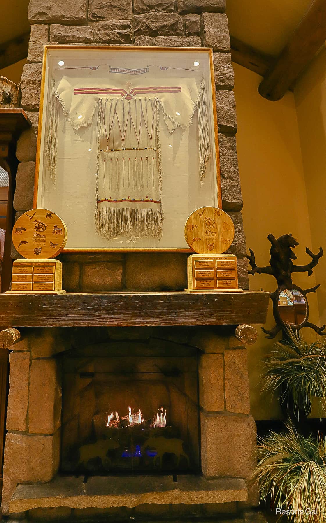 an Indian costume on display over the fireplace in Wilderness Lodge Mercantile