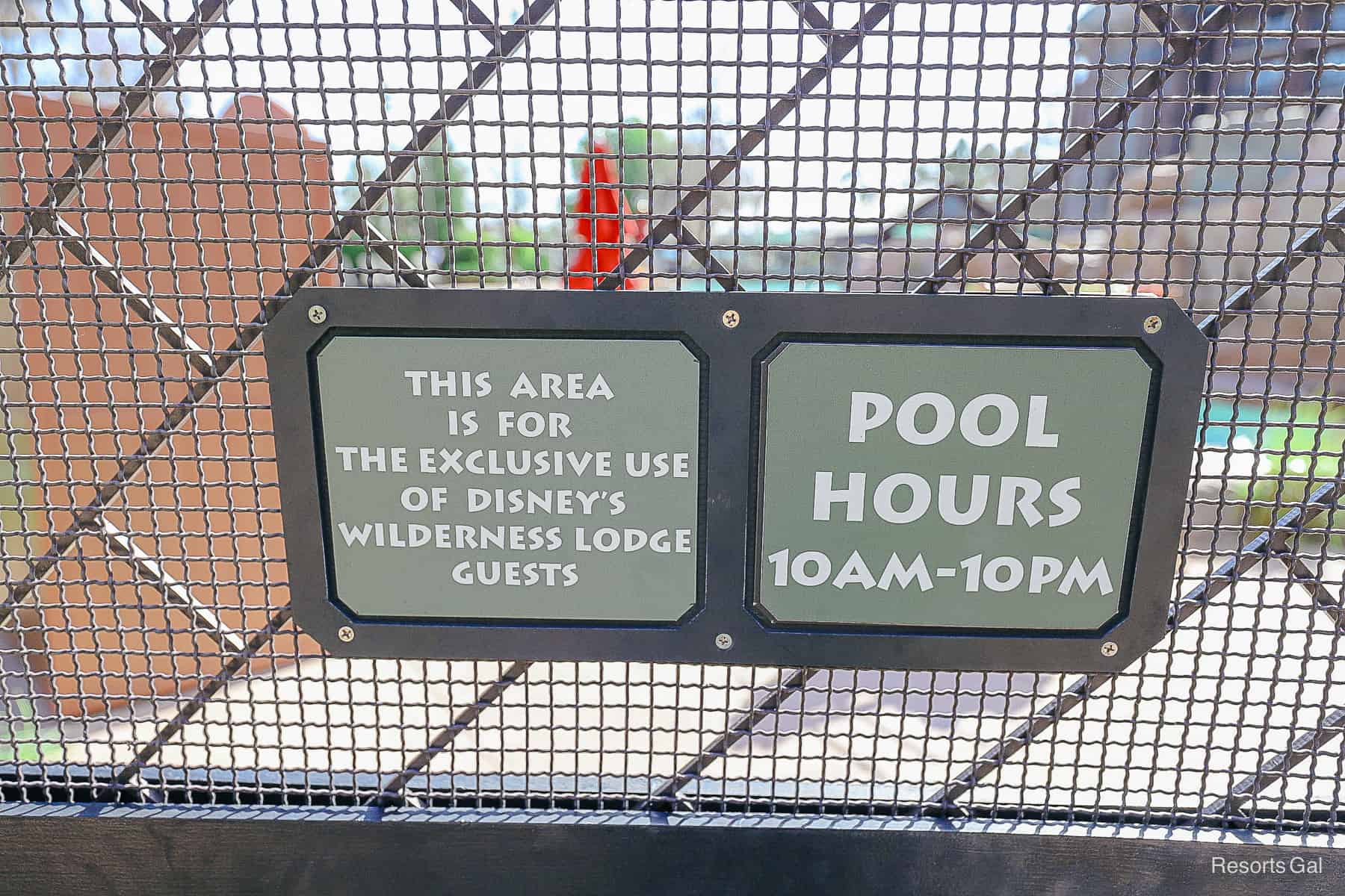 a sign with the posted pool hours and says that the area is exclusive to Disney's Wilderness Lodge guests 