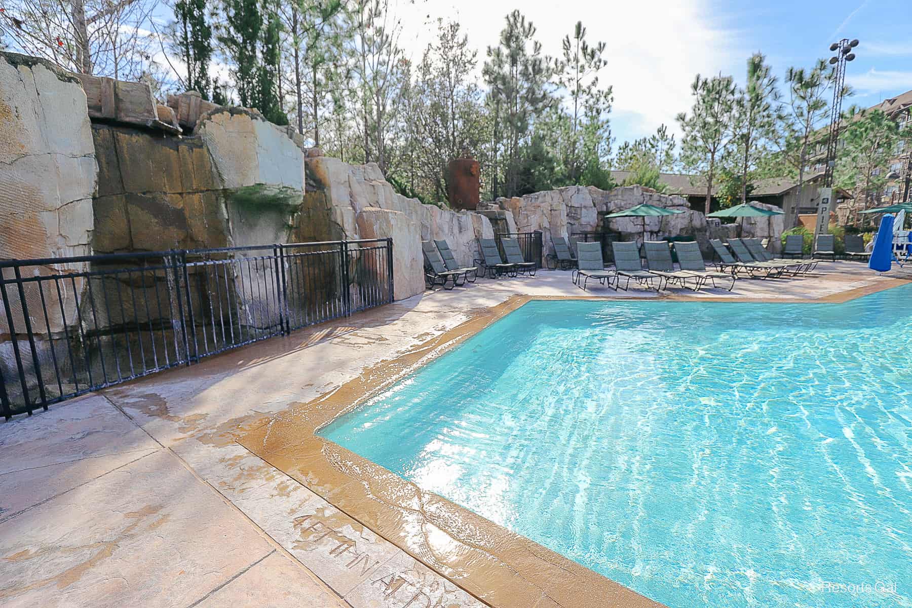 the side of the pool where water runs over the rocks and into the pool 