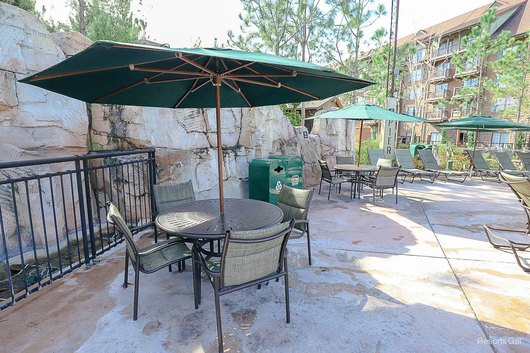 tables and chairs in the shade with privacy boulders around them 