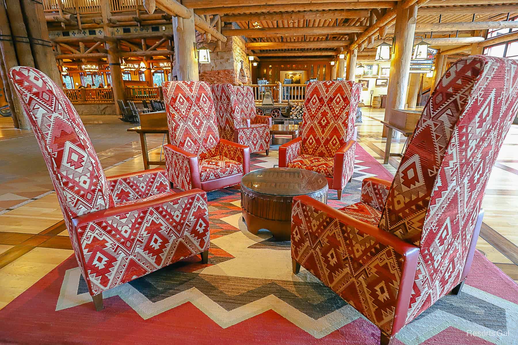 a set of four tall red chairs with a small table between them 