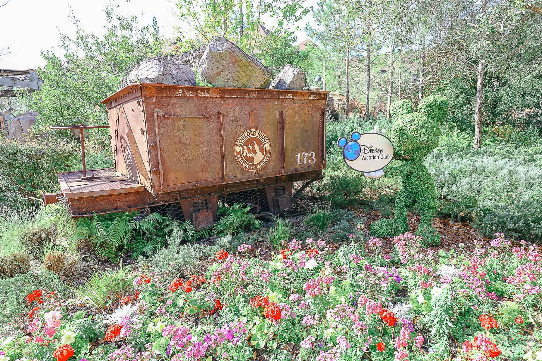 a Disney Vacation Club sign with Mickey Topiary