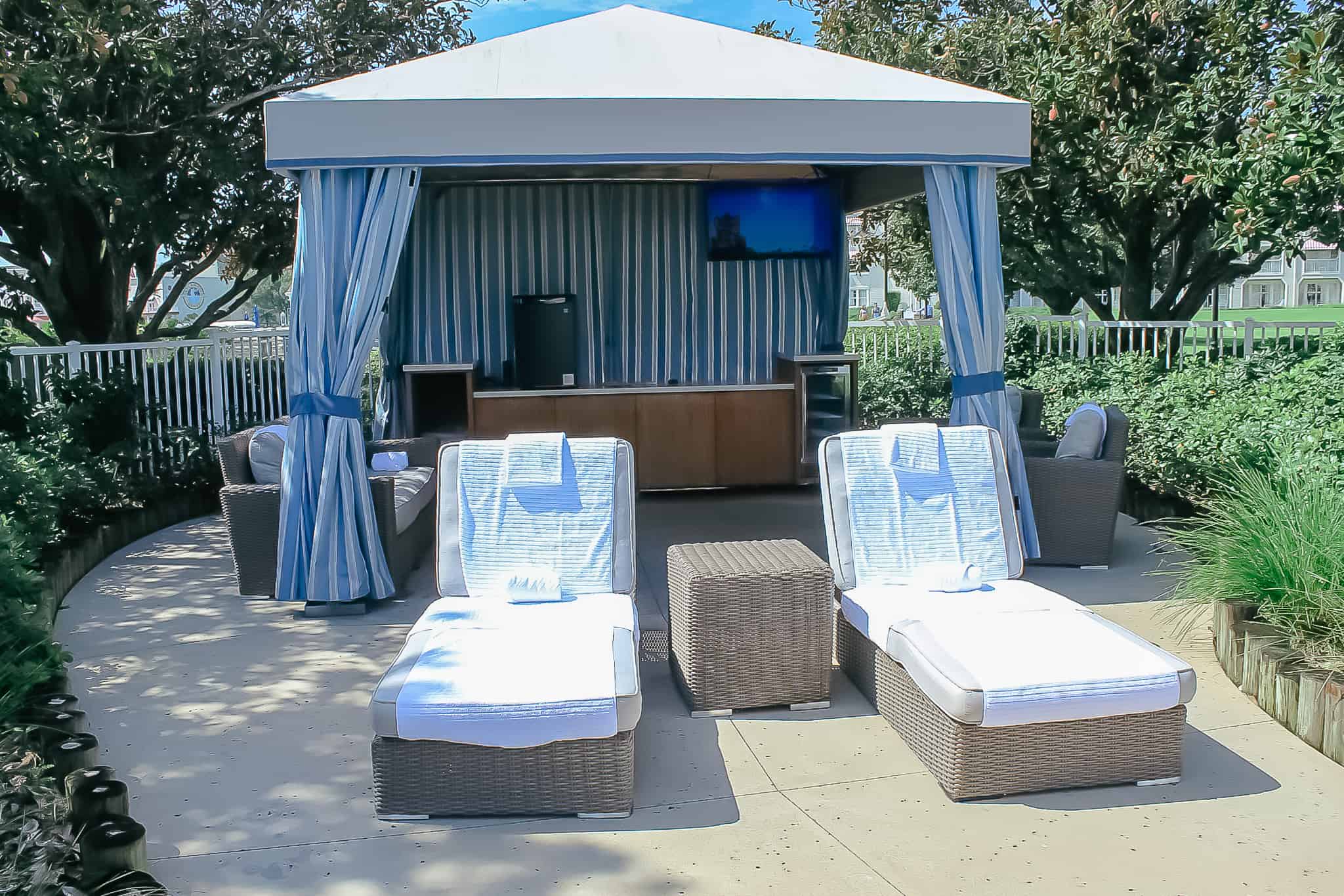 a cabana with two lounge chairs in front of it 
