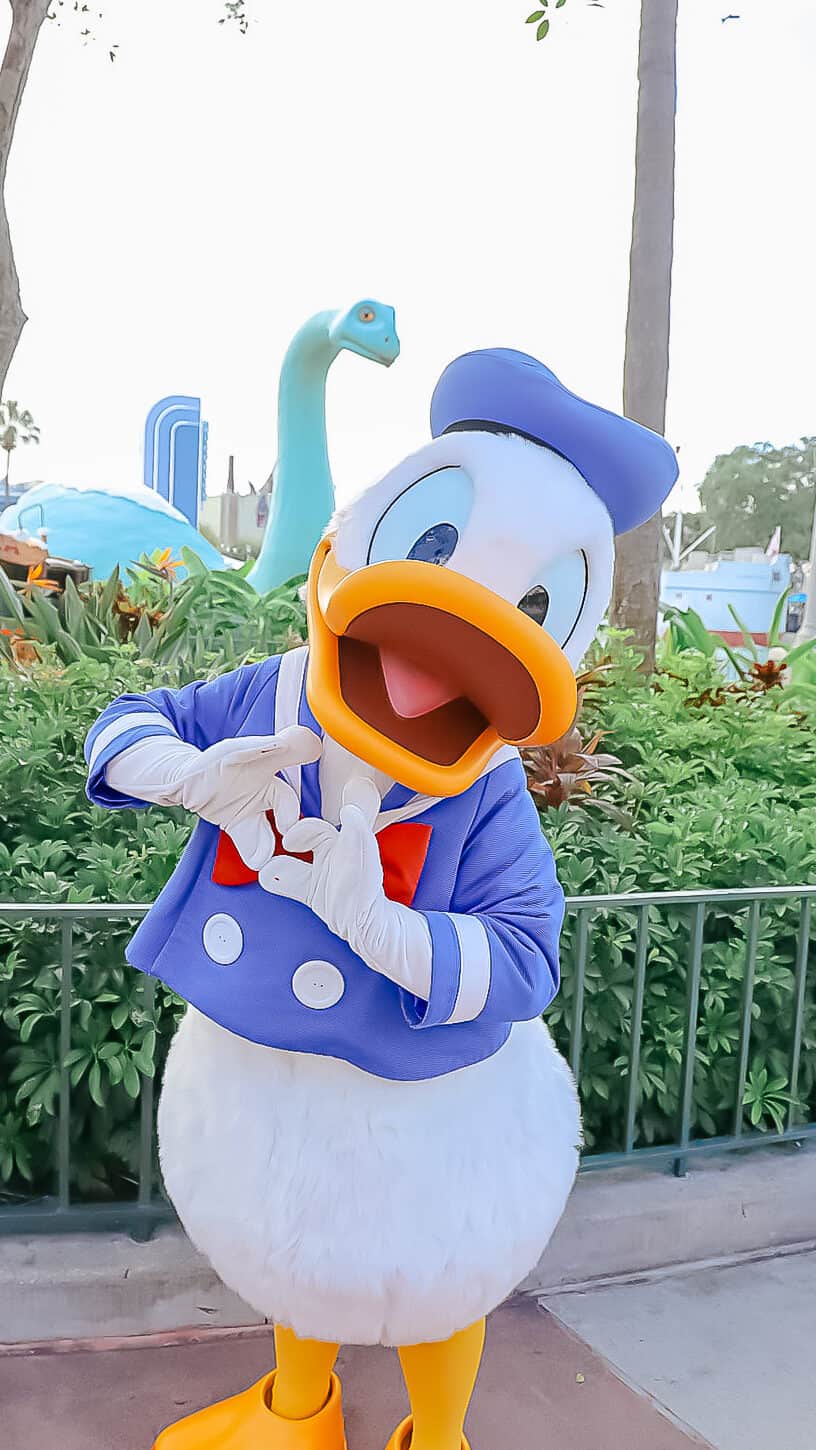 Donald in classic blue poses with a heart shape.