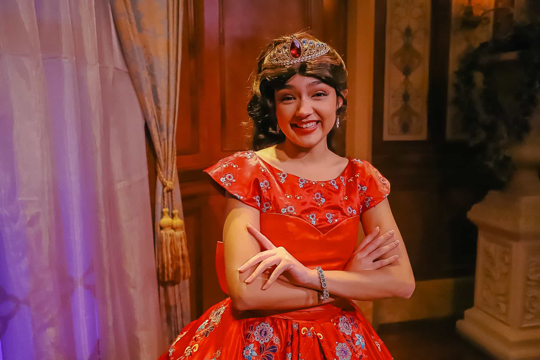 Elena wearing a red dress with embroidered flowers. 