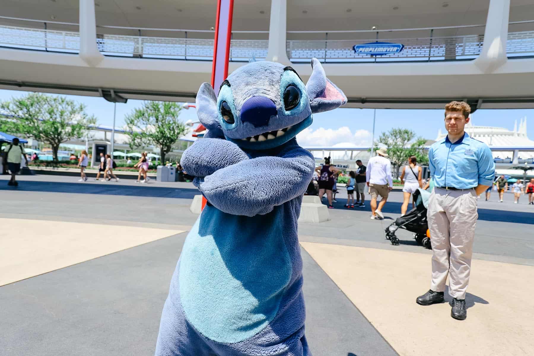 Stitch poses in Tomorrowland with his arms crossed. 