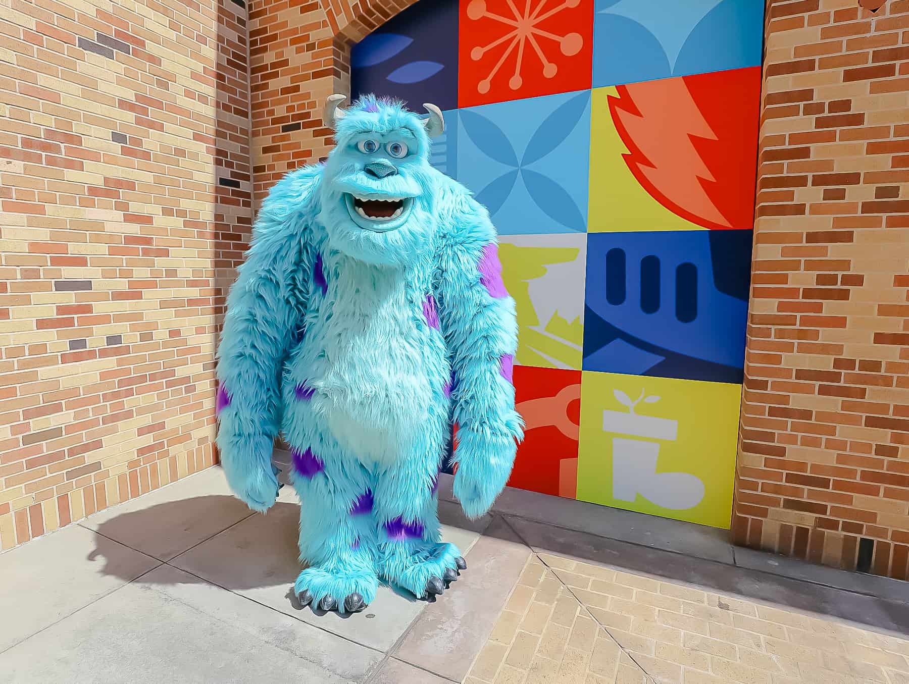 Sulley posing in front of a Pixar backdrop. 