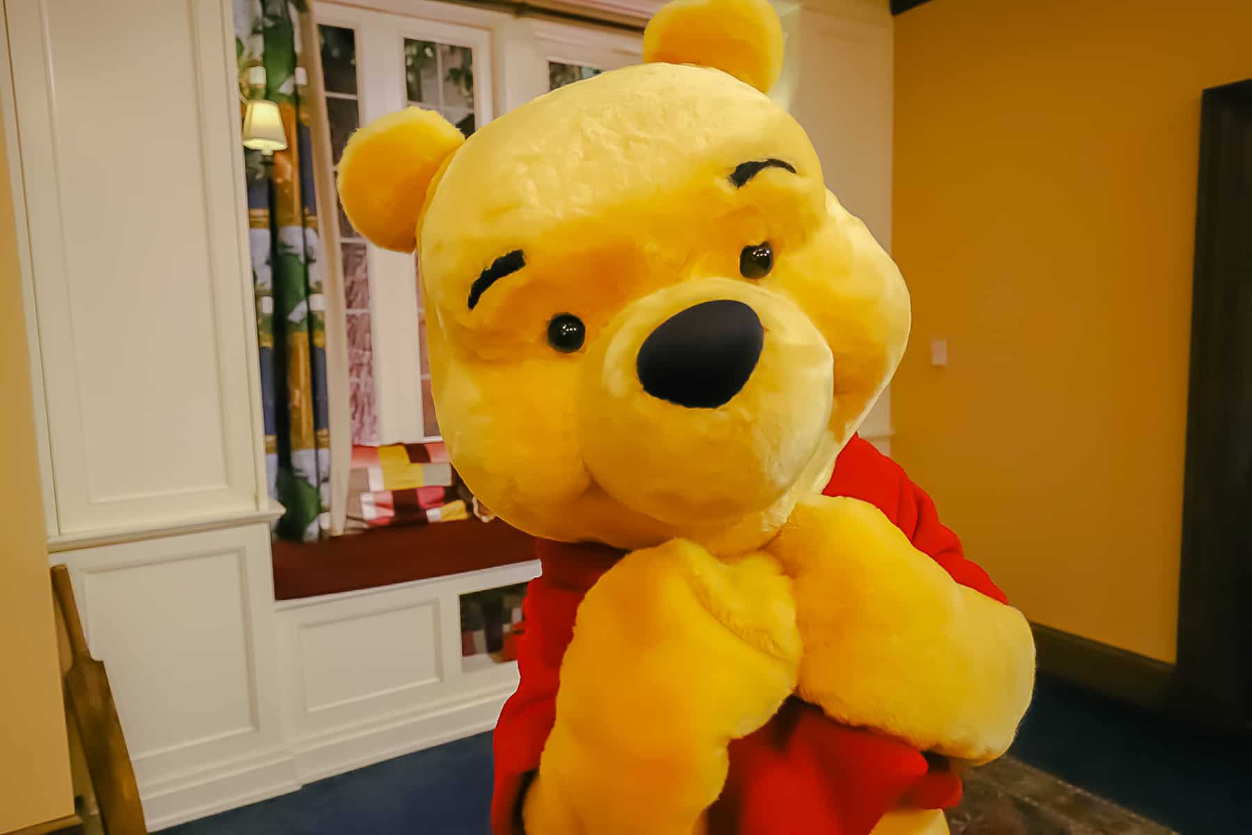 Winnie the Pooh poses with his arms to his chin. 
