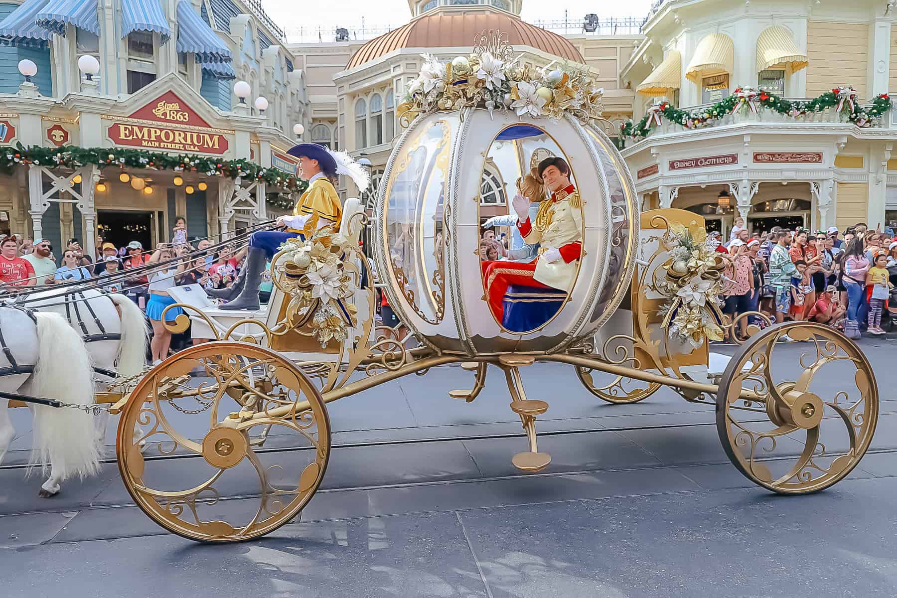 Prince Charming waves to the crowd from inside Cinderella's carriage. 