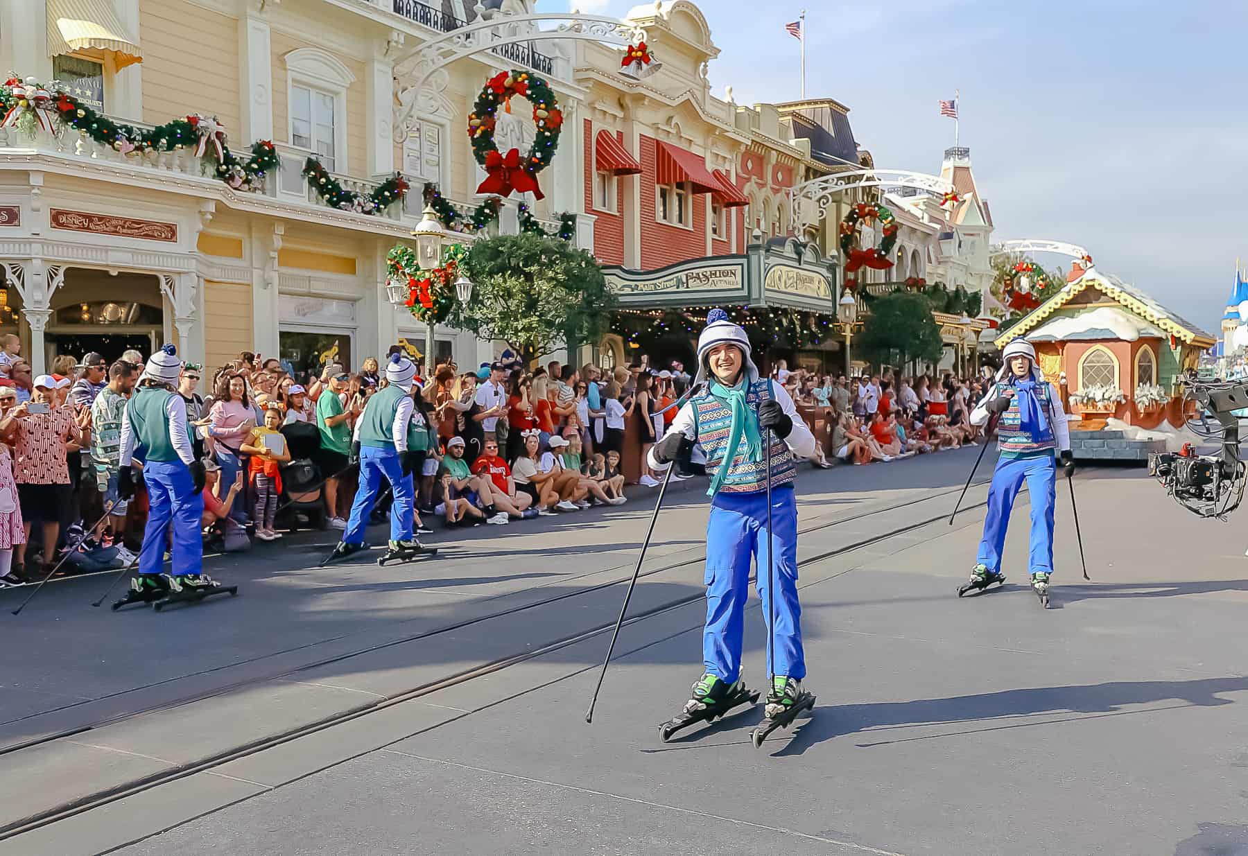 Skiers race through the parade on roller blades with winter outfits. 