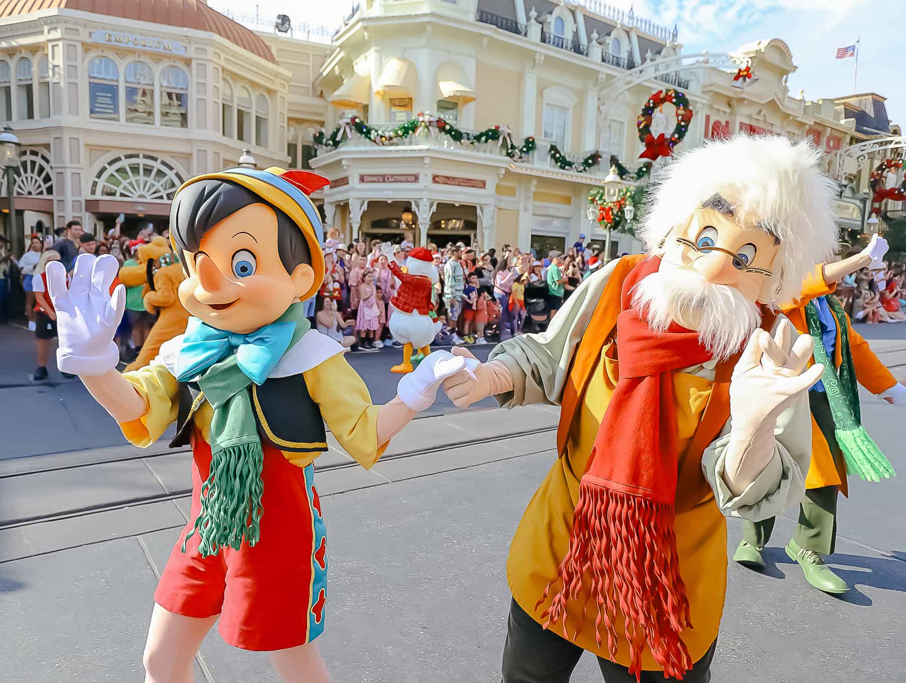 Pinocchio and Gepetto waving to the camera in Magic Kingdom's Christmas Parade. 