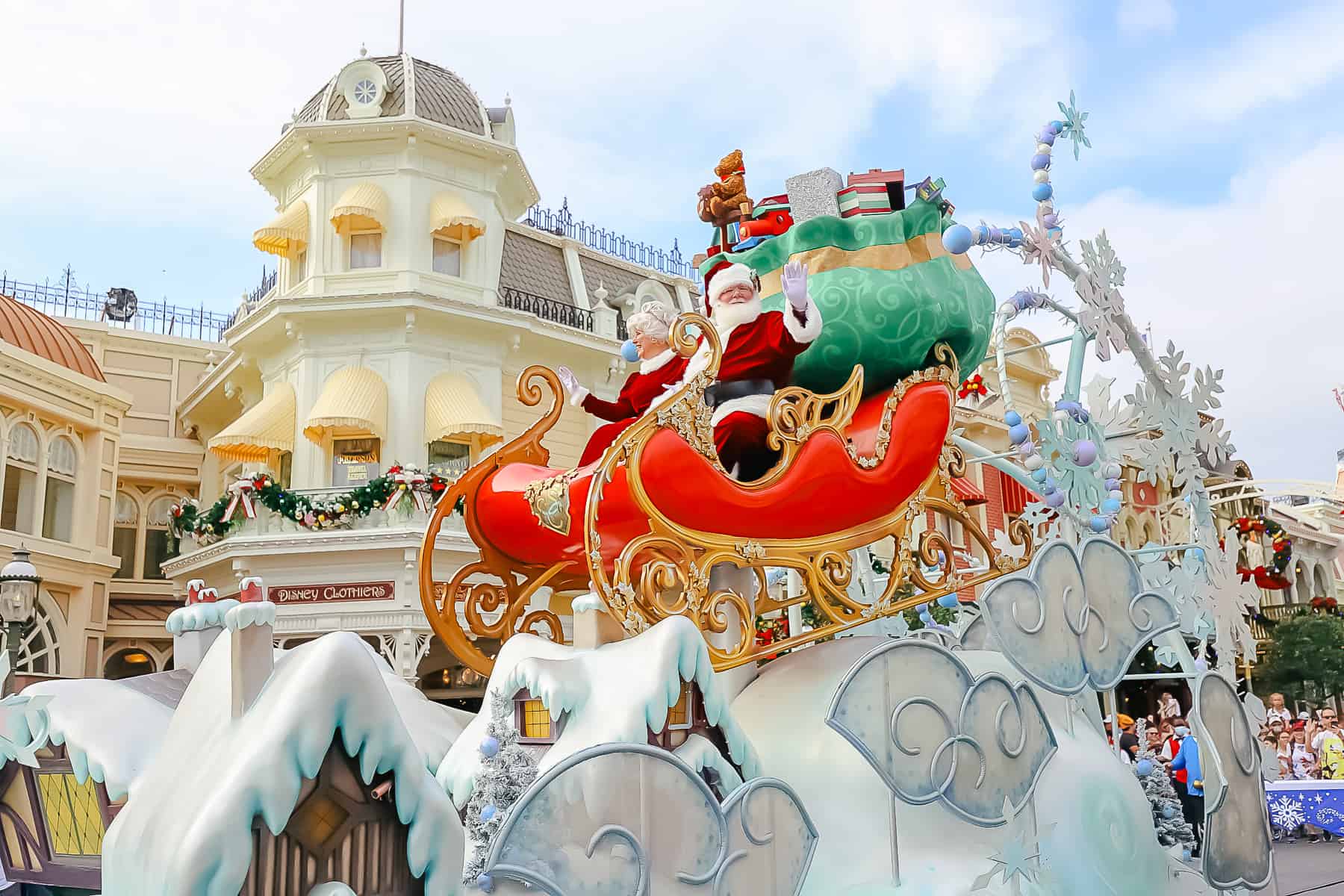 Close up of Santa and Mrs. Claus in the sleigh. A large sack of toys sits behind them. 