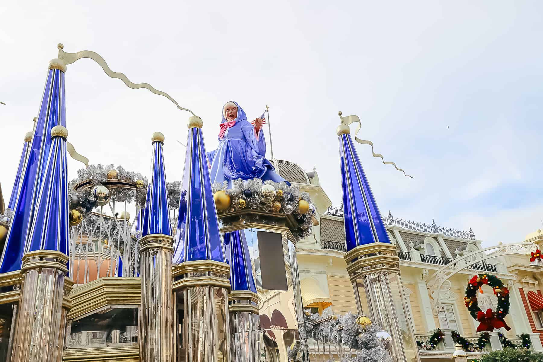 The Fairy Godmother makes a surprise face as she looks down from the top of her parade float.