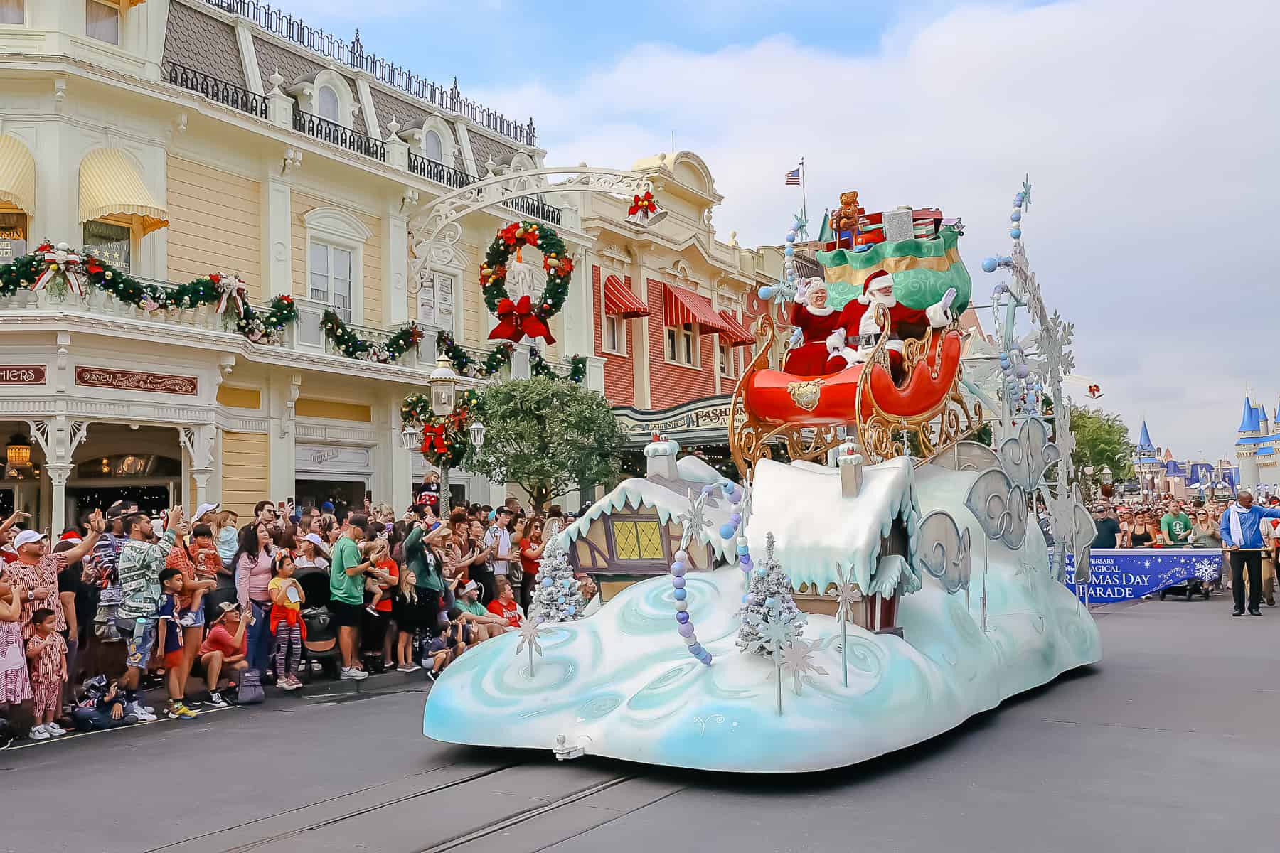 Santa and Mrs. Claus in Disney's Christmas parade. The float is a sleigh that's perched on snow covered roof. 