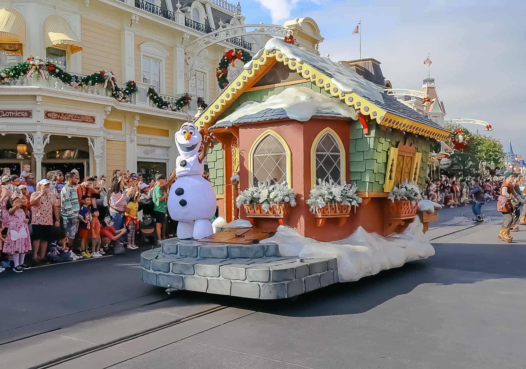 Olaf waves to the crowd from his float during a daytime performance. 