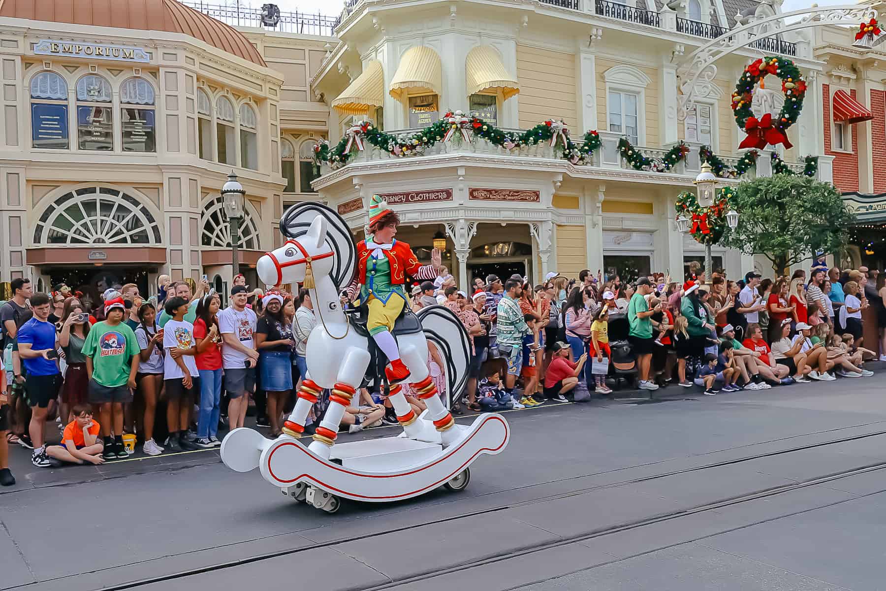 An elf rides a wooden rocking horse along the parade route. 