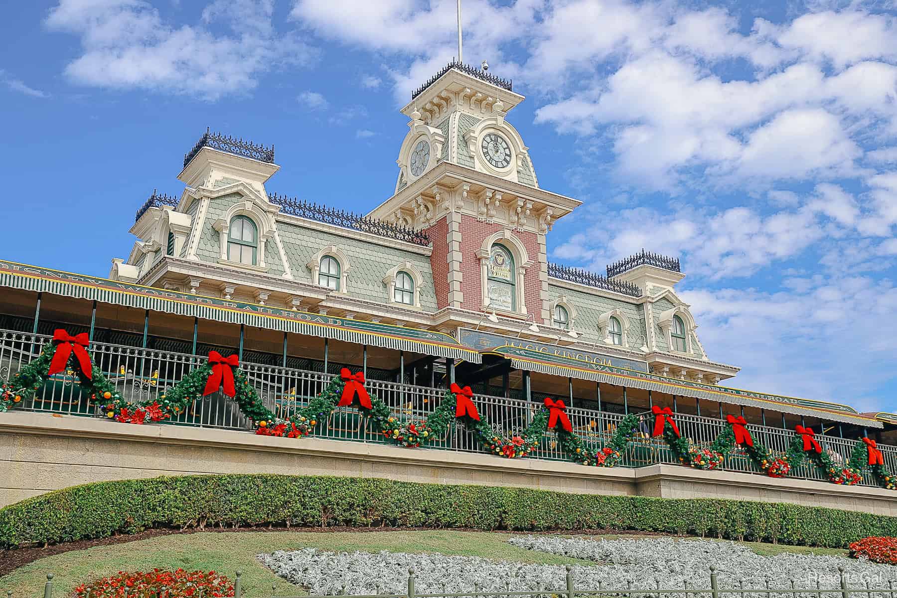 Magic Kingdom entrance at Christmas time with garland and red bows 