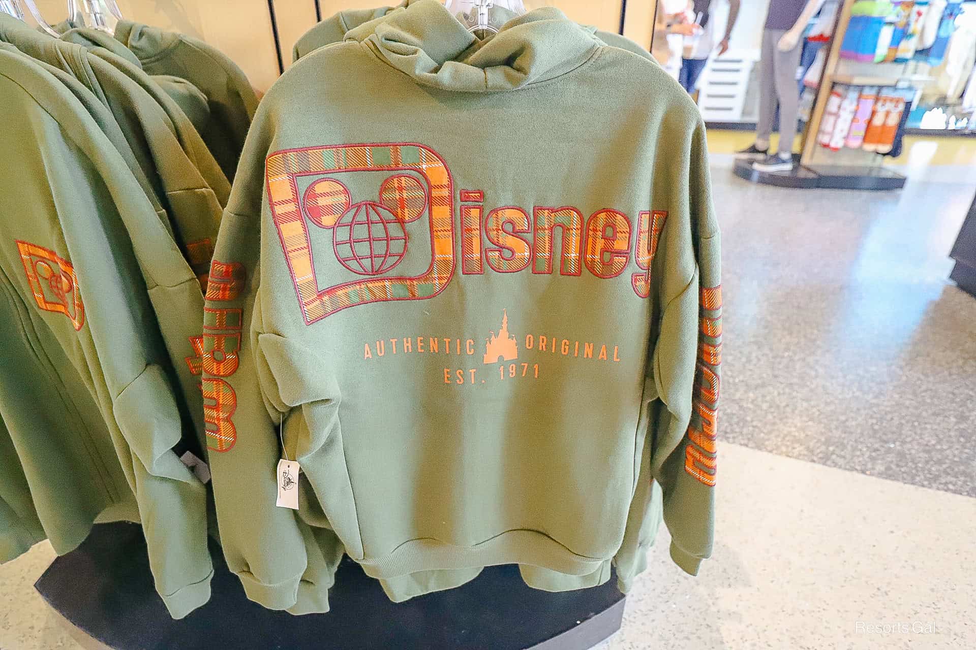 back of the logo zip up hoodie jacket with plaid Fall colors on olive green backdrop