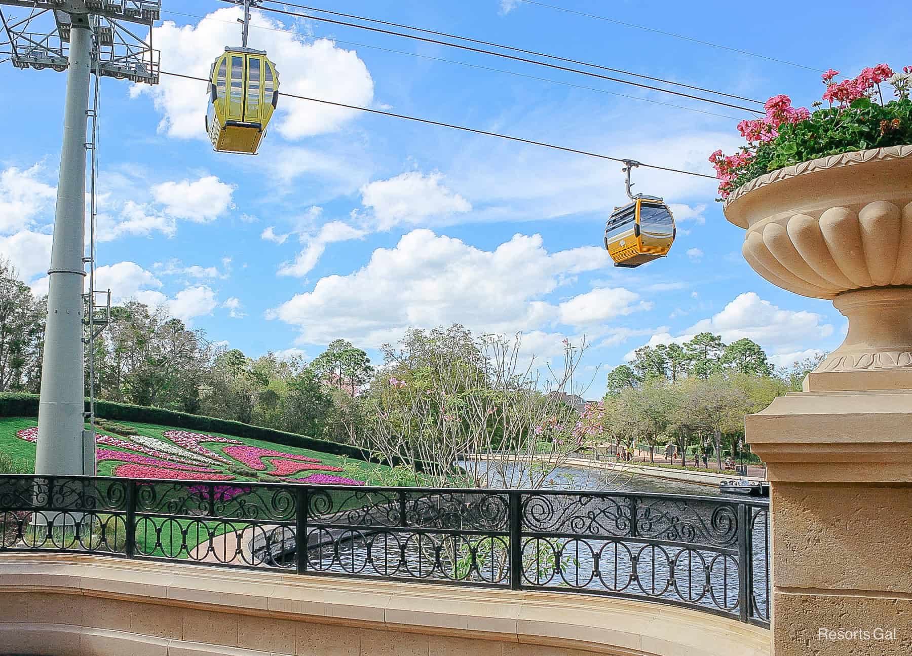 two Skyliner gondolas sailing over Spring flowers 